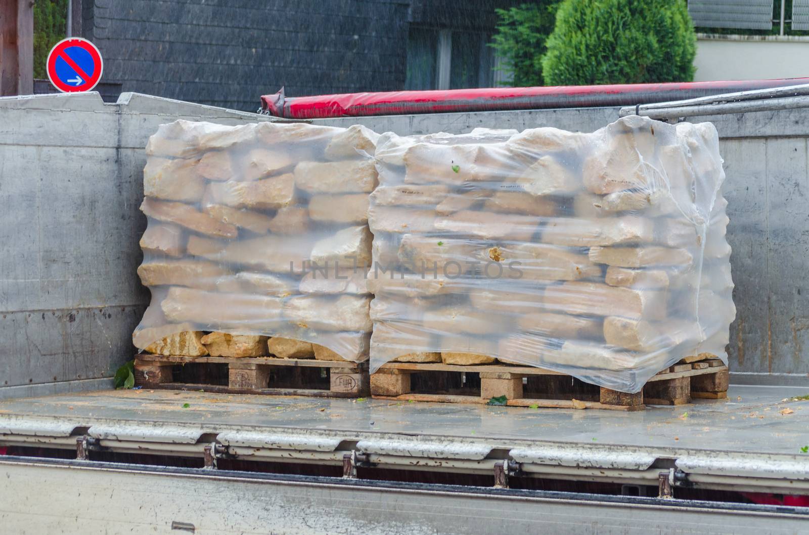 Pallets with sandstones are delivered and unloaded from a truck.