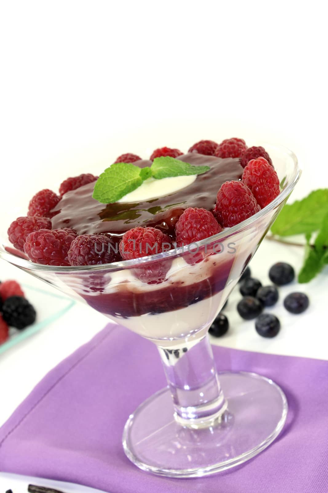 Layered dessert with blueberries and raspberries on a light background