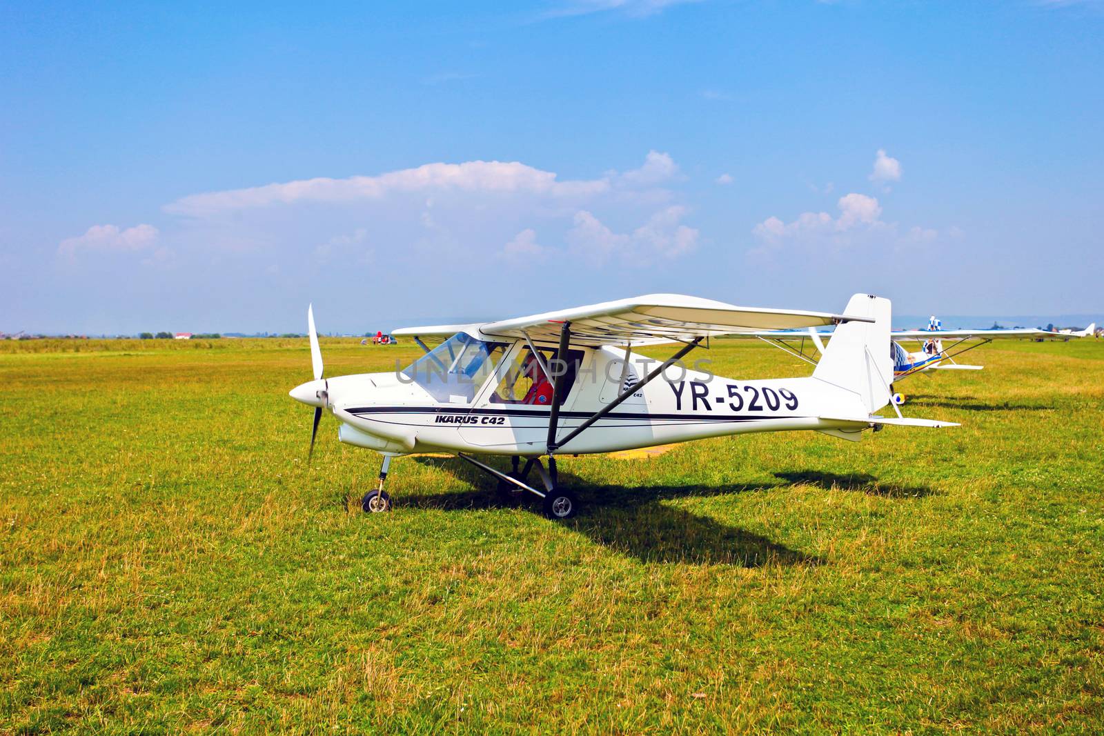 Brasov, Romania - August 12, 2010: White airplane on a green grass field prepared to take off for a flight show