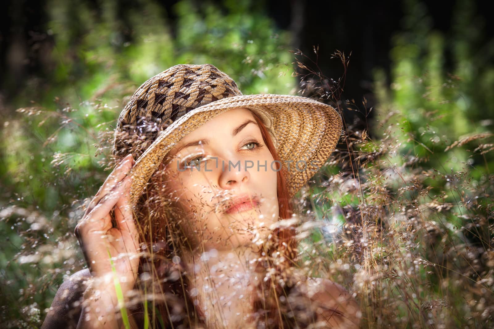 Young woman in the grass on natural background in the sunlight