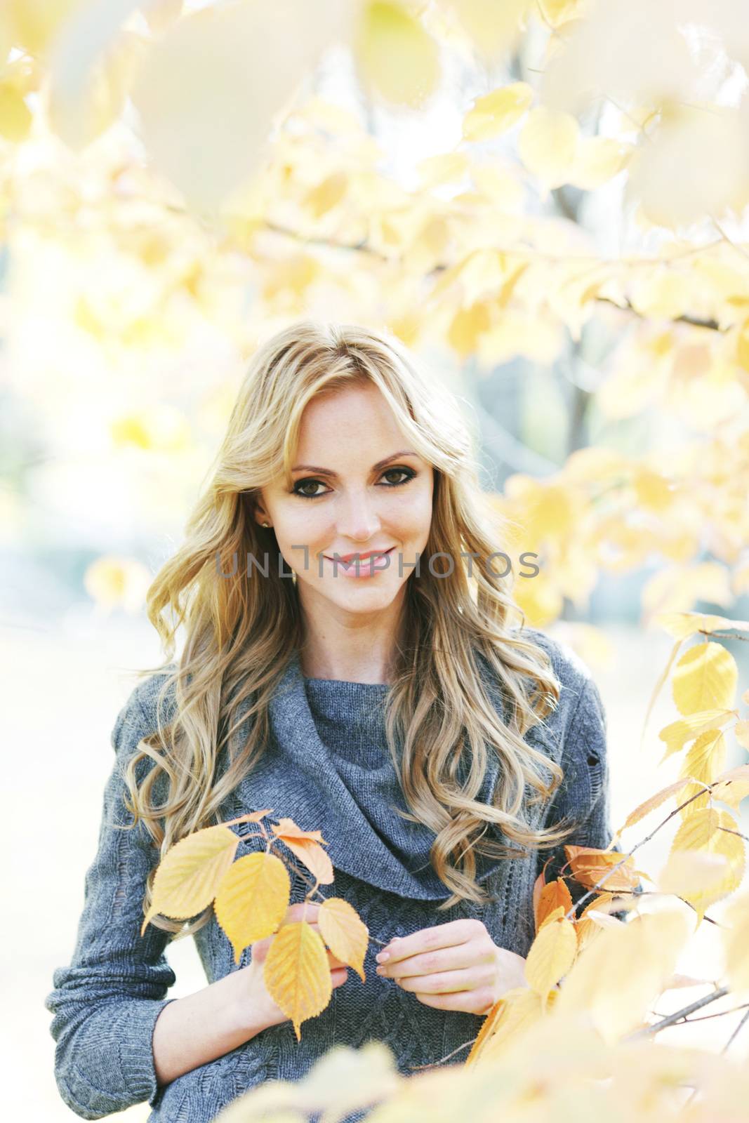 Portrait of beautiful young woman outdoors in autumn park