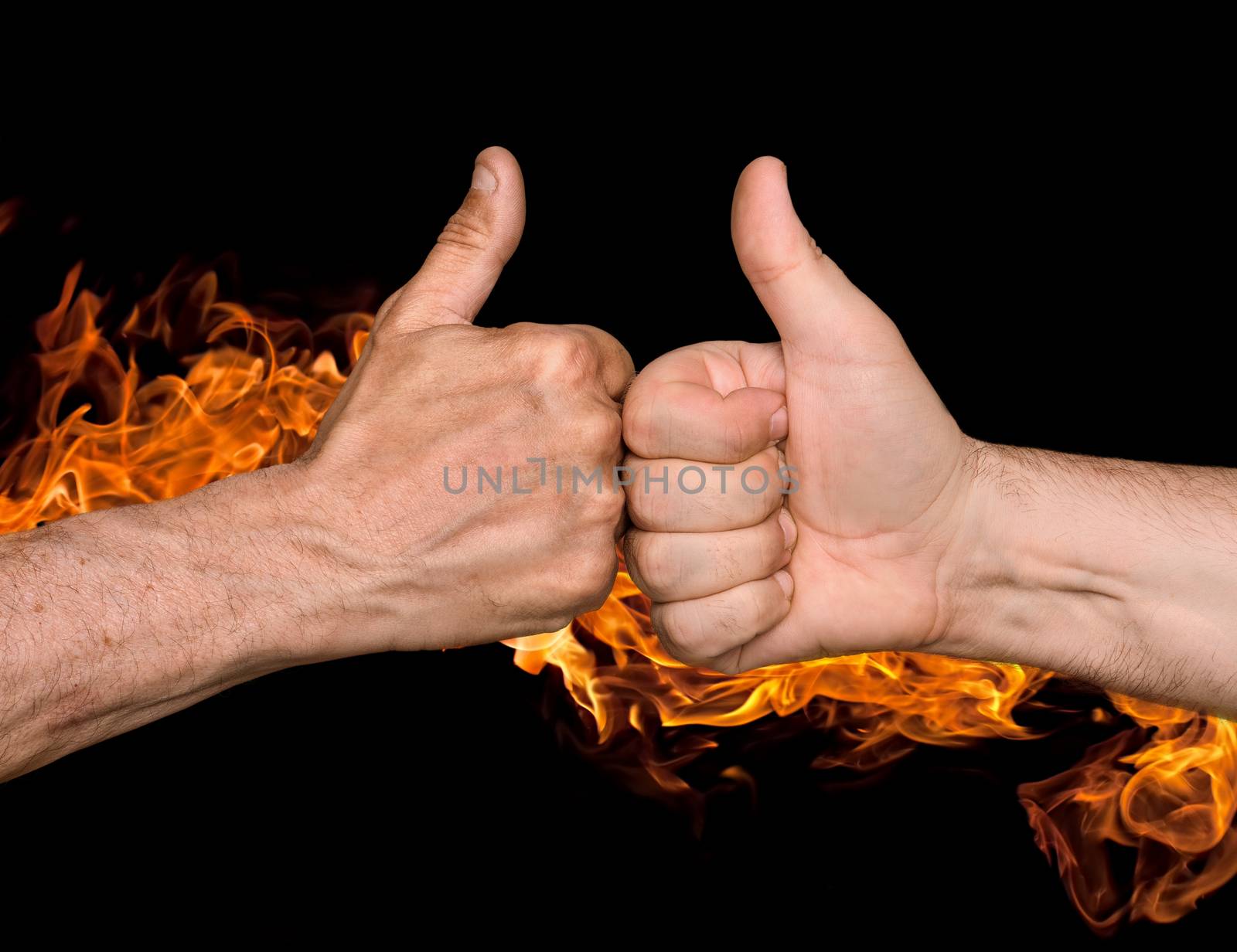 Friendship sealed with fire concept. Two men bumping fists with thumbs up against the fire flames