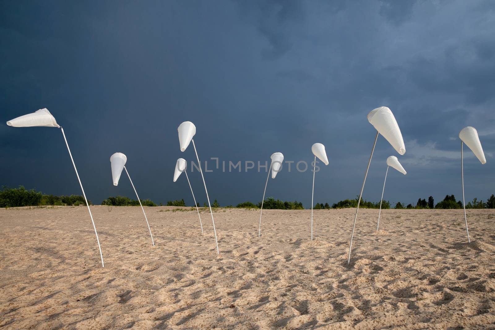 Abstract landscape with with white plastic cones and stormy sky background
