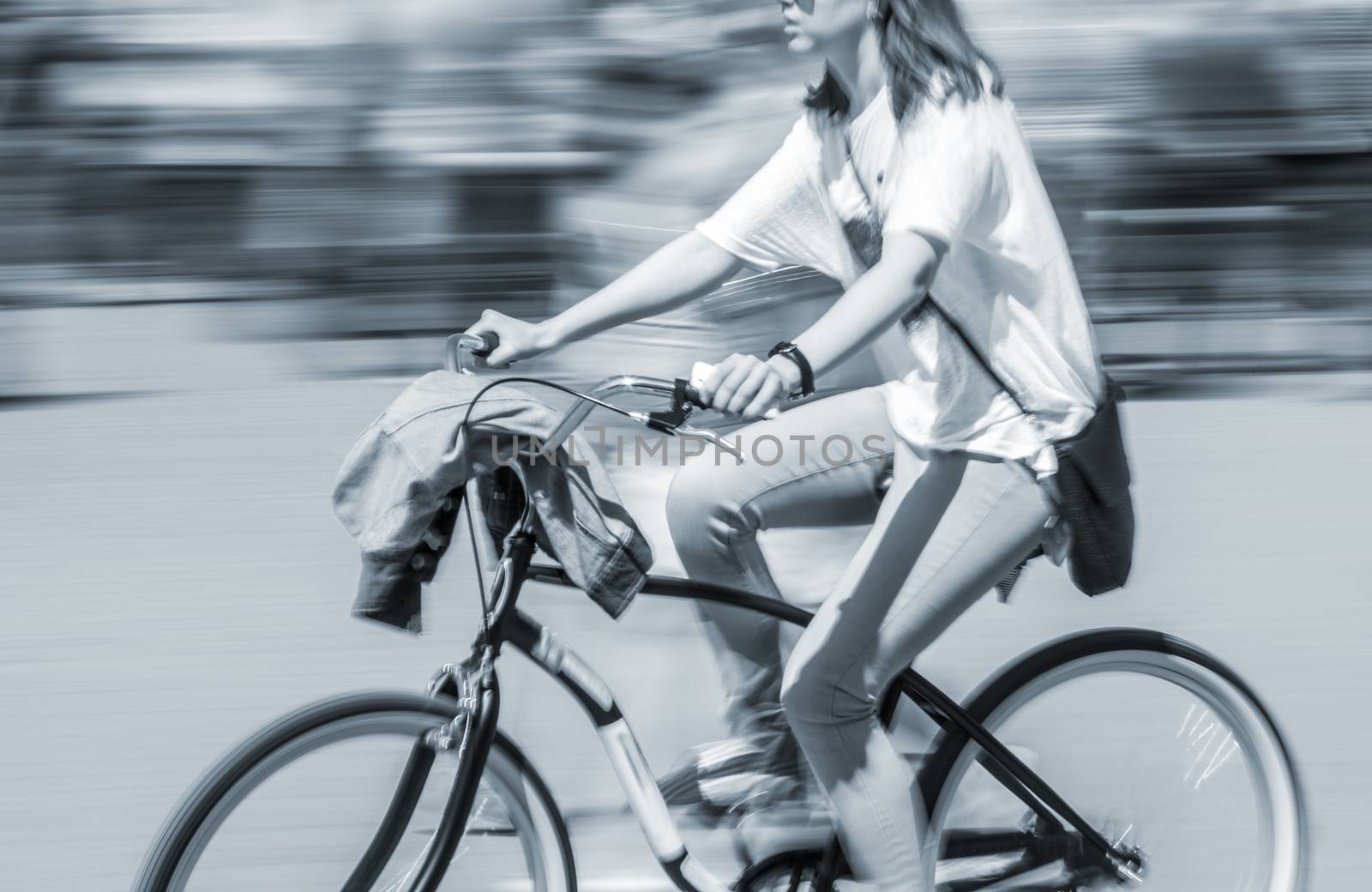 Cyclist in traffic on the city roadway. Intentional motion blur
