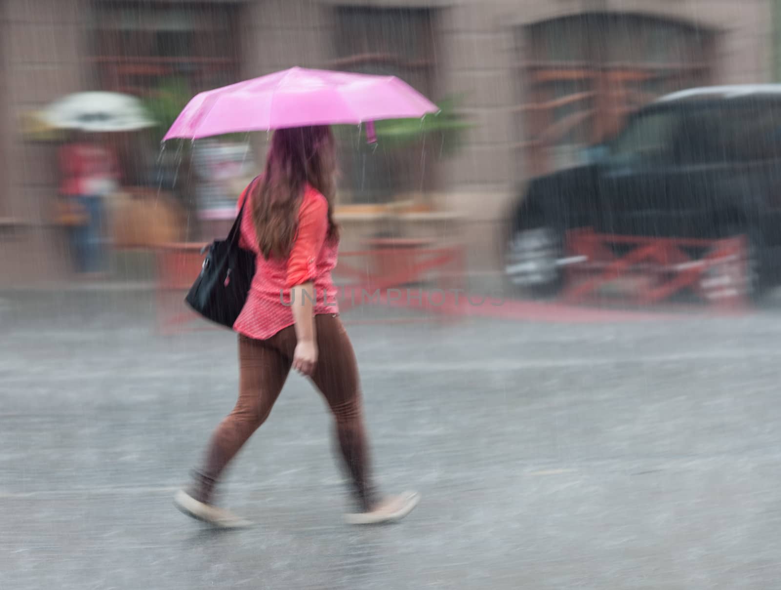 People walking down the street in rainy day. Intentional motion blur