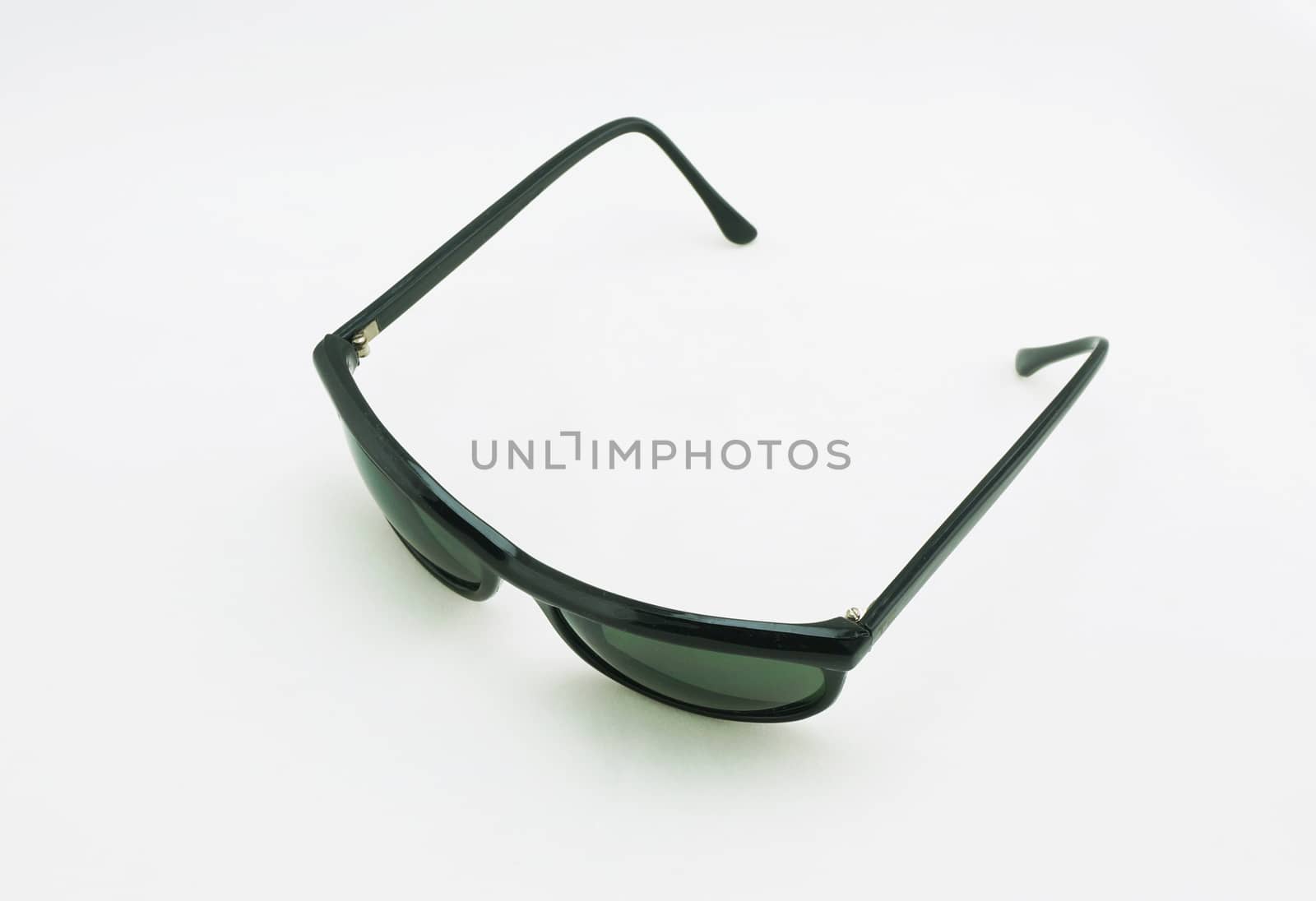 Black sunglasses outstretched arms placed on a white background.                               