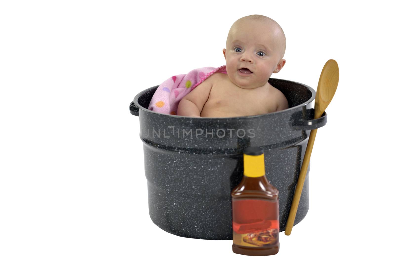 Six month baby girl sitting in a saucepan 