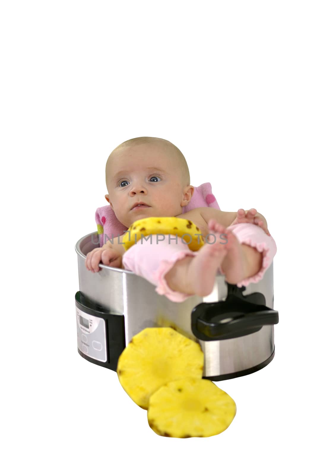6 month baby girl lying in a saucepan with slices of pineapple