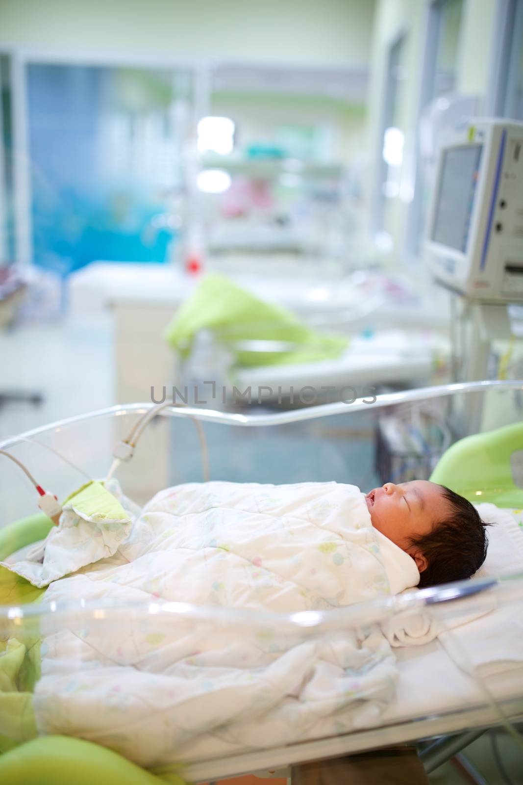 Newborn infant sleeping in hospital bassinet