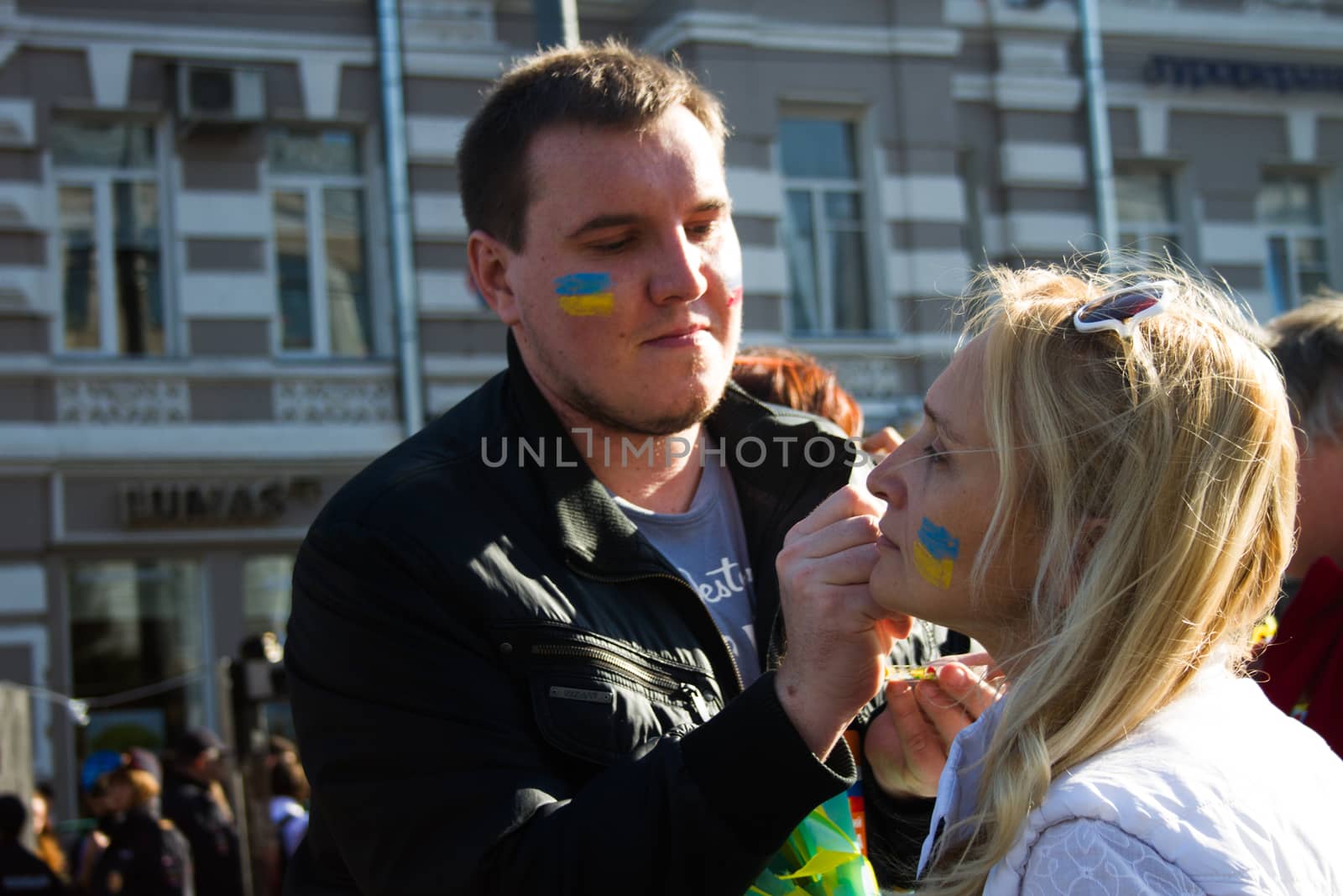 Moscow, Russia - September 21, 2014. Peace March participants draw on their faces Ukrainian flag Peace March in Moscow against war with Ukraine