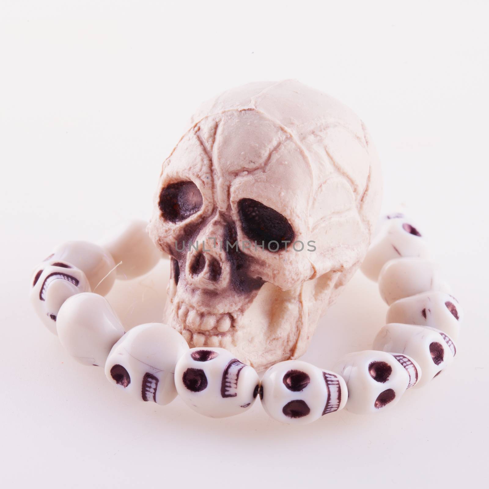 Skull with skull necklace over white background