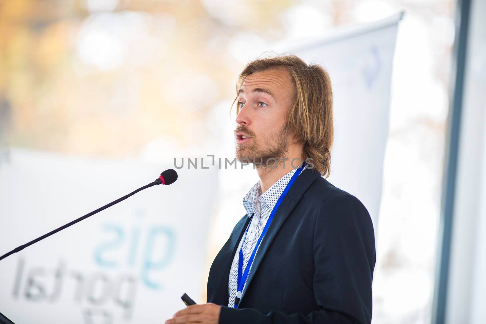 Handsome young man giving a speech at a conference by viktor_cap