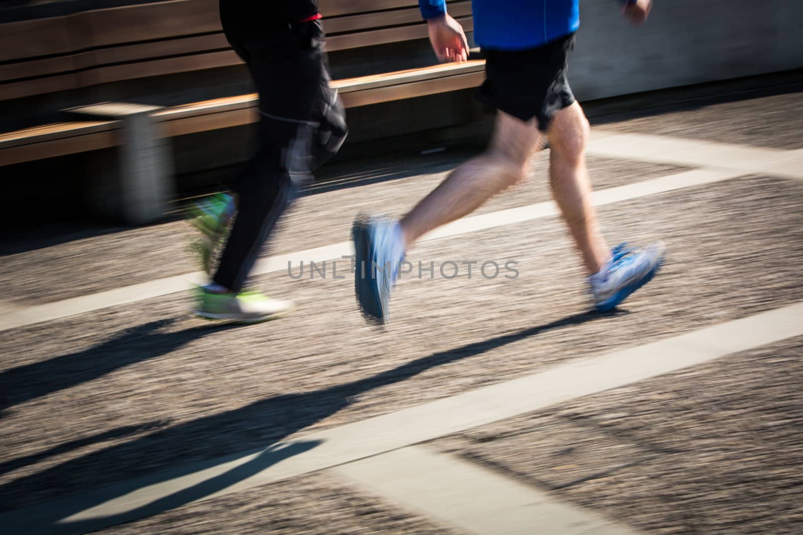 Motion blurred runner's feet in a city environment by viktor_cap