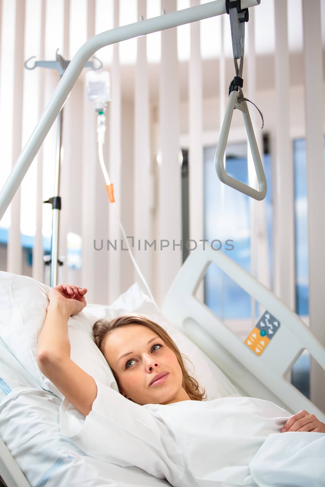 Pretty, young, female patient in a modern hospital room.