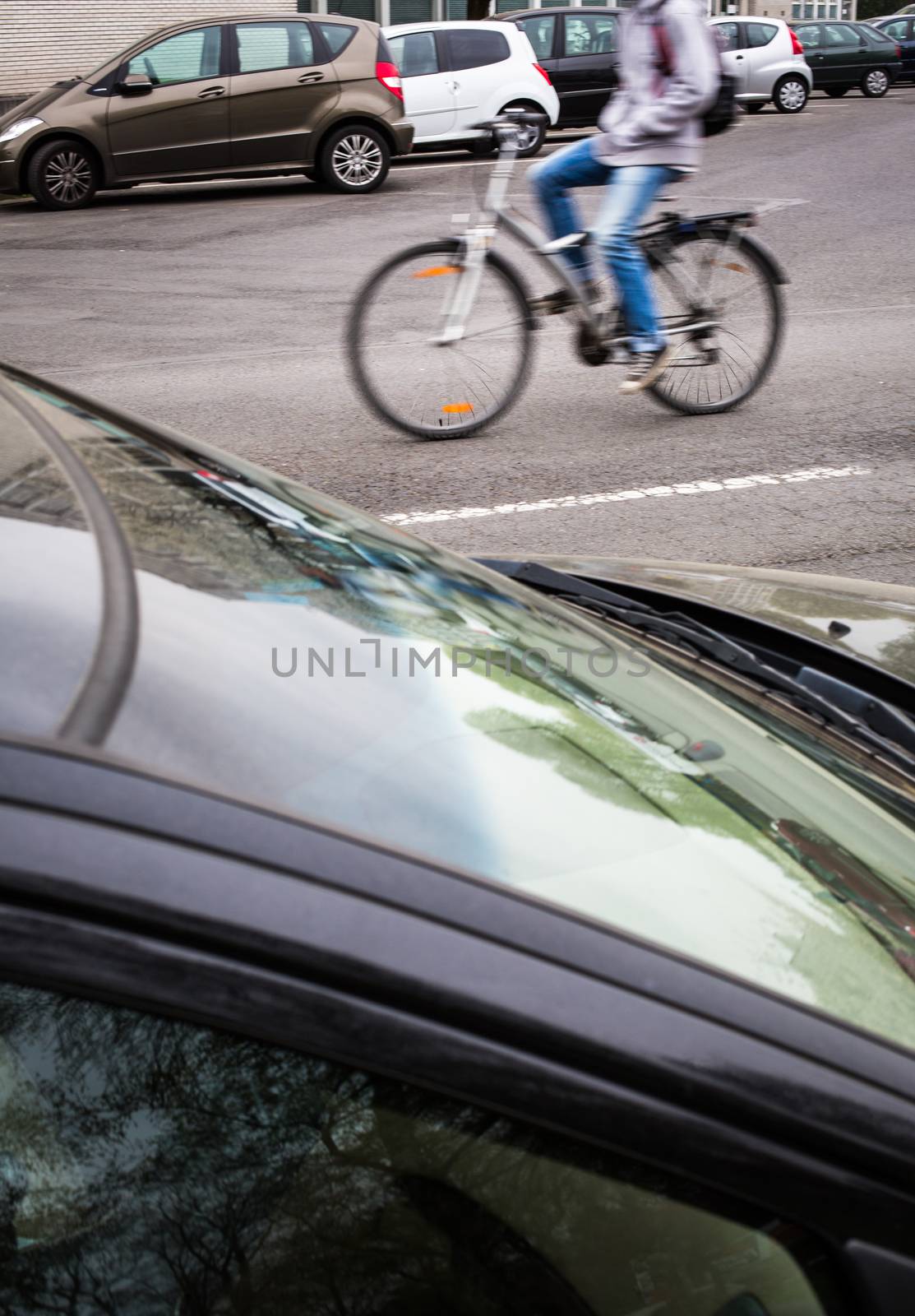 Motion blurred female biker on a city street, going fast