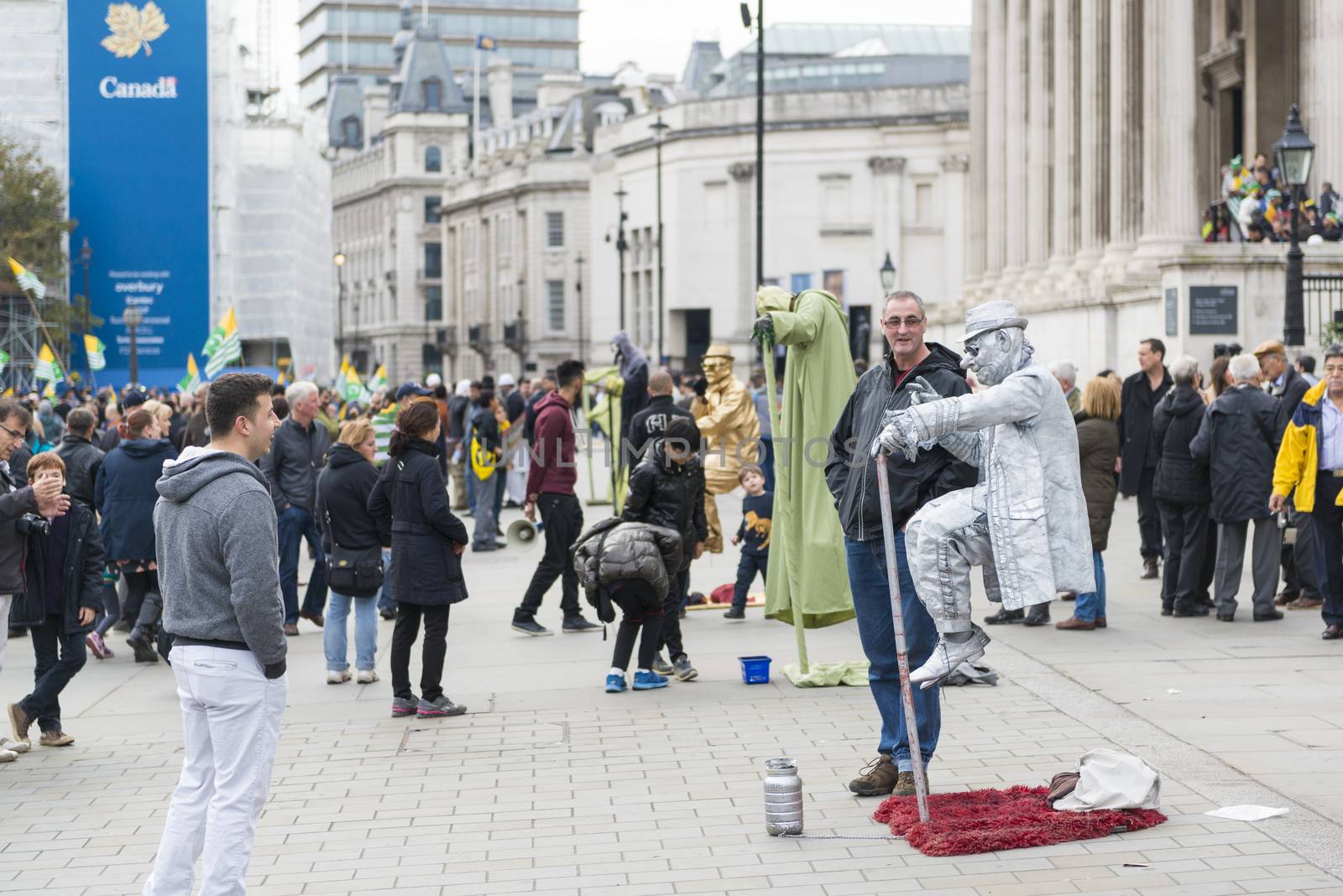 LONDON, UK - OCTOBER 26: Street artists levitating in busy Trafalgar Square. In central London, street artists must obtain a permit in order to perform in public spaces. October 26, 2014 in London.