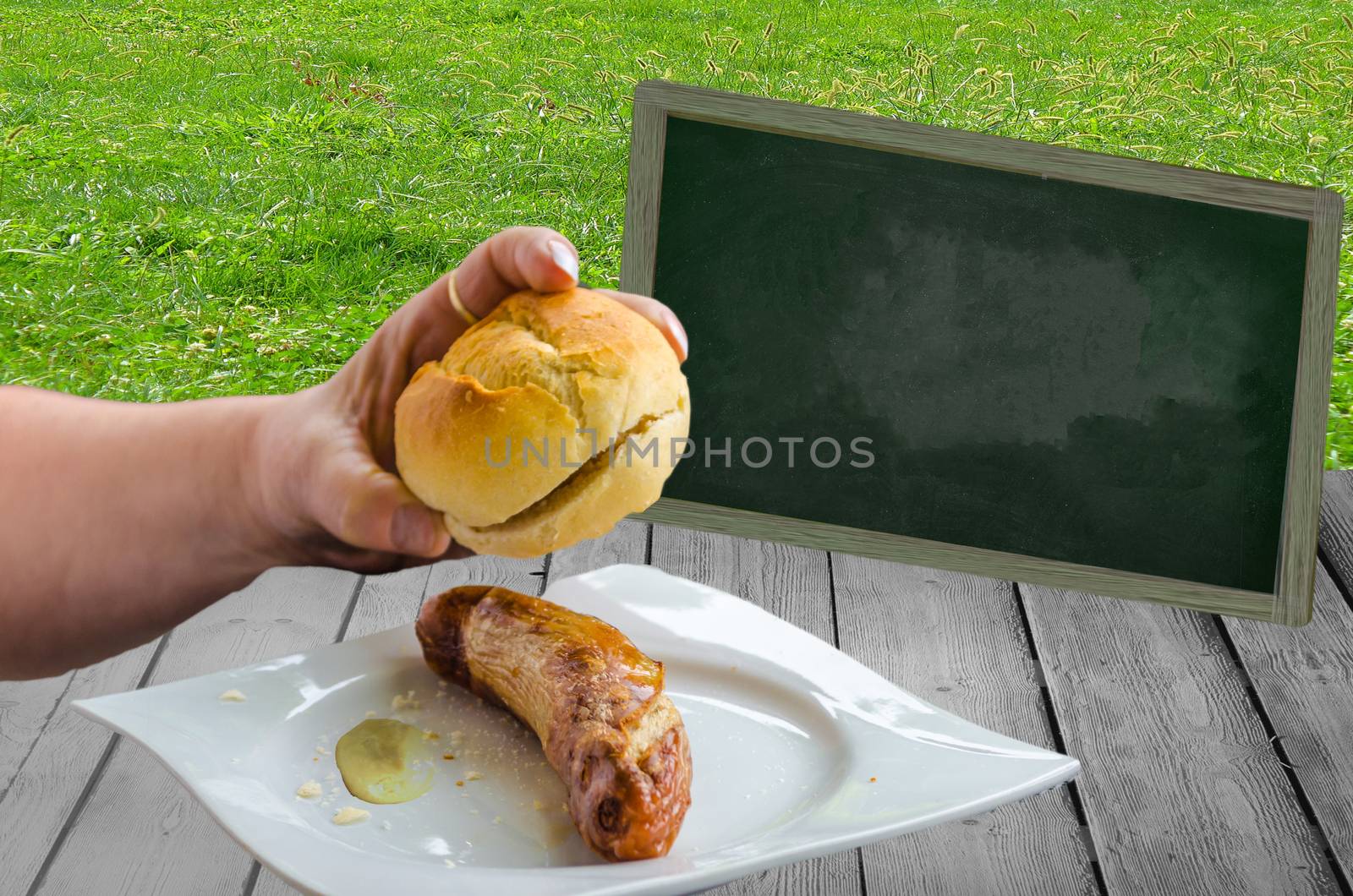 A bratwurst with bun on a white plate with mustard
