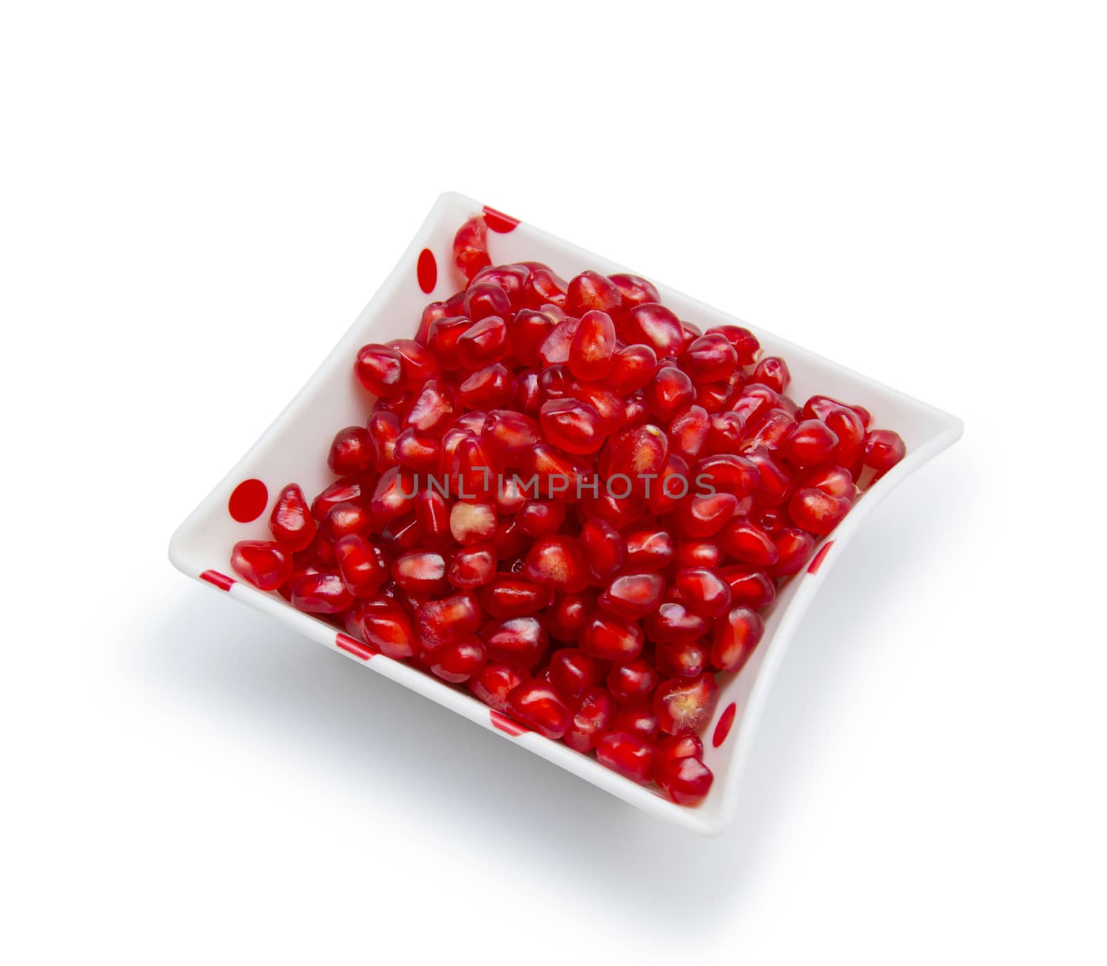 Loose pomegranate seeds in a white bowl