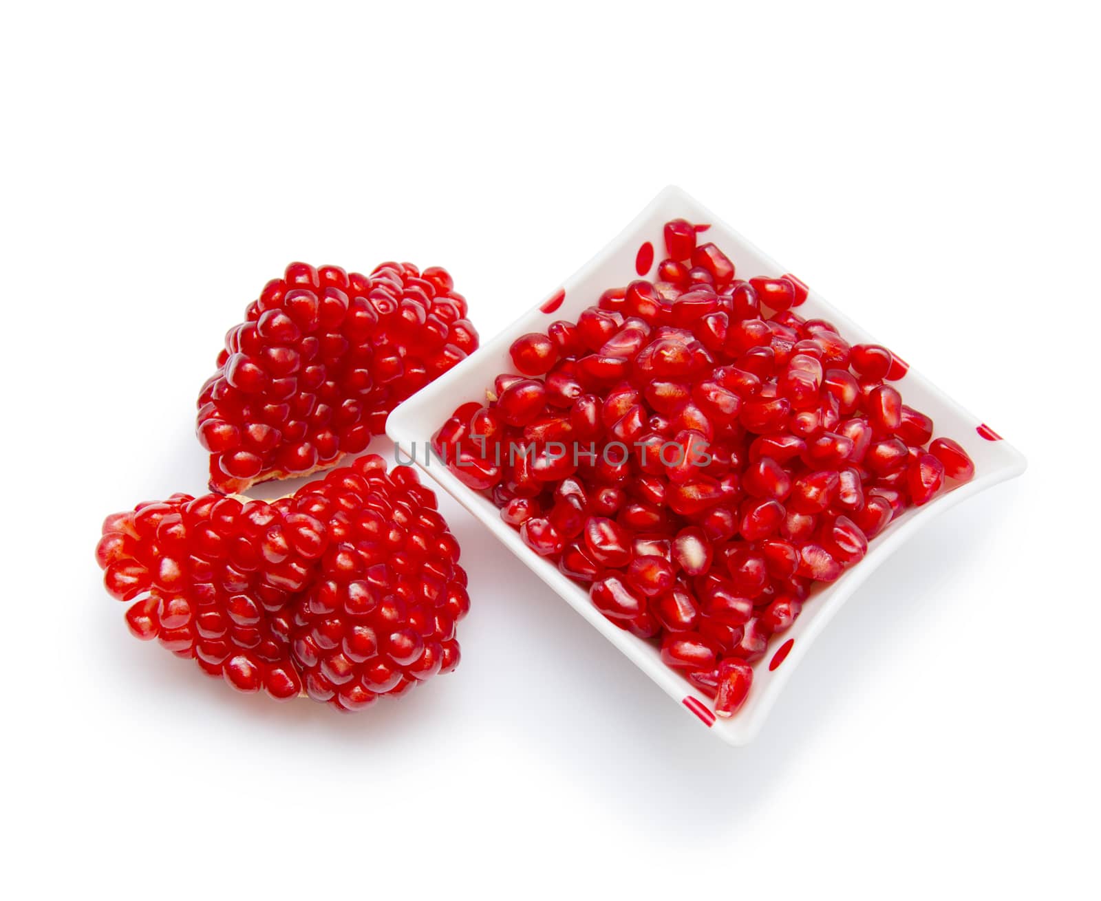 Loose pomegranate seeds in a white bowl by cocoo