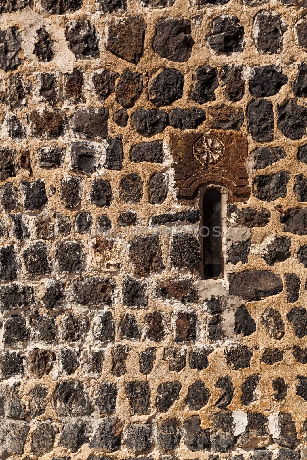 fragment of a stone wall of a fortress with a small window