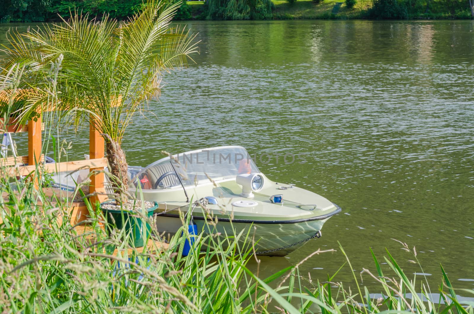 Small motor boat at the dock moored on a palm tree is fixed.