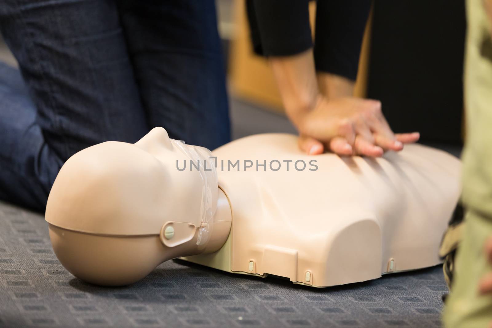 A group of adult education students practitcing CPR chest compressioon on a dummy. 