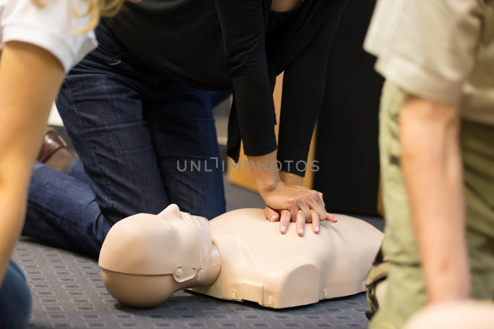 A group of adult education students practitcing CPR chest compressioon on a dummy. 