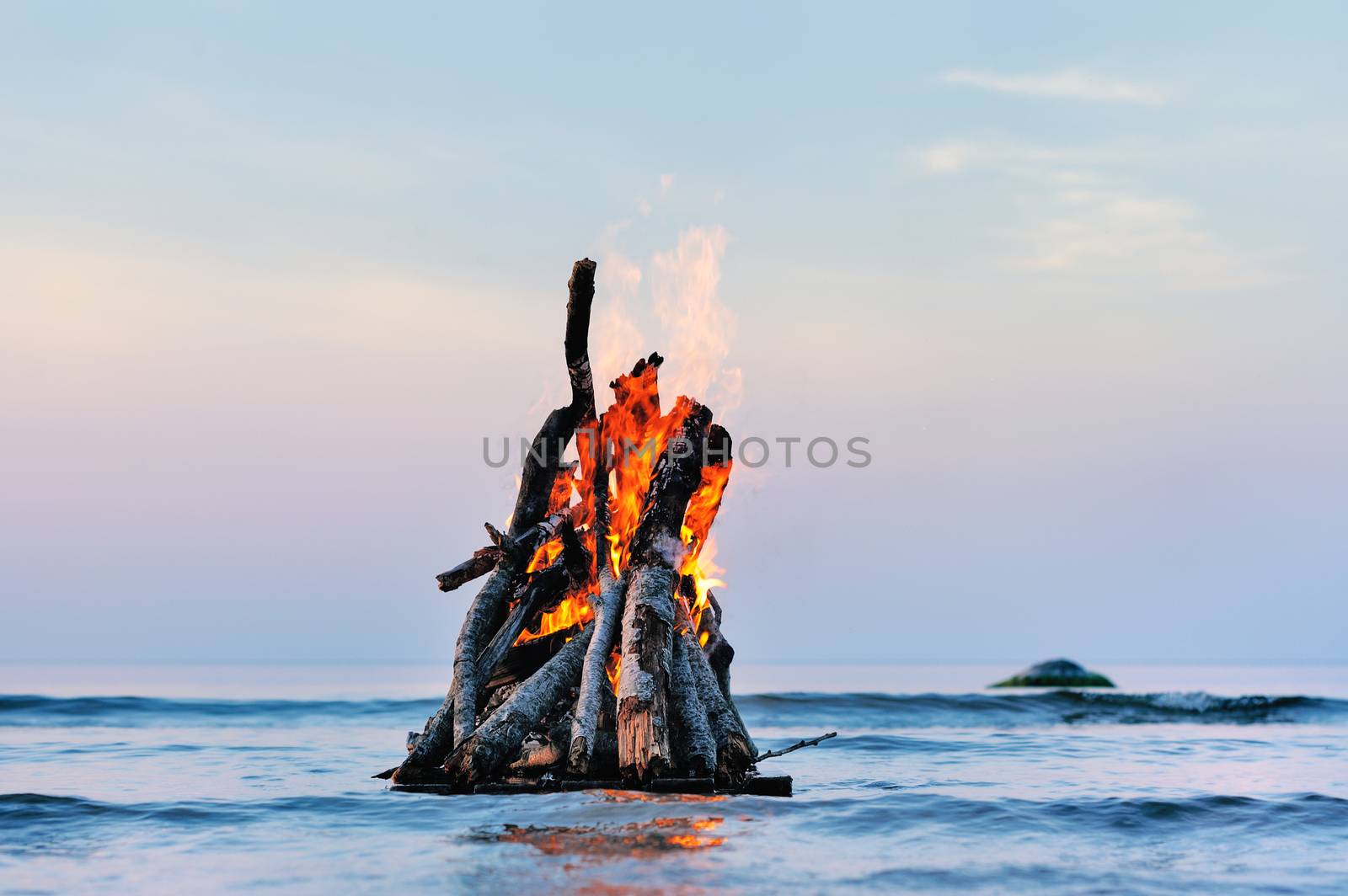 Bright campfire on the sea surface