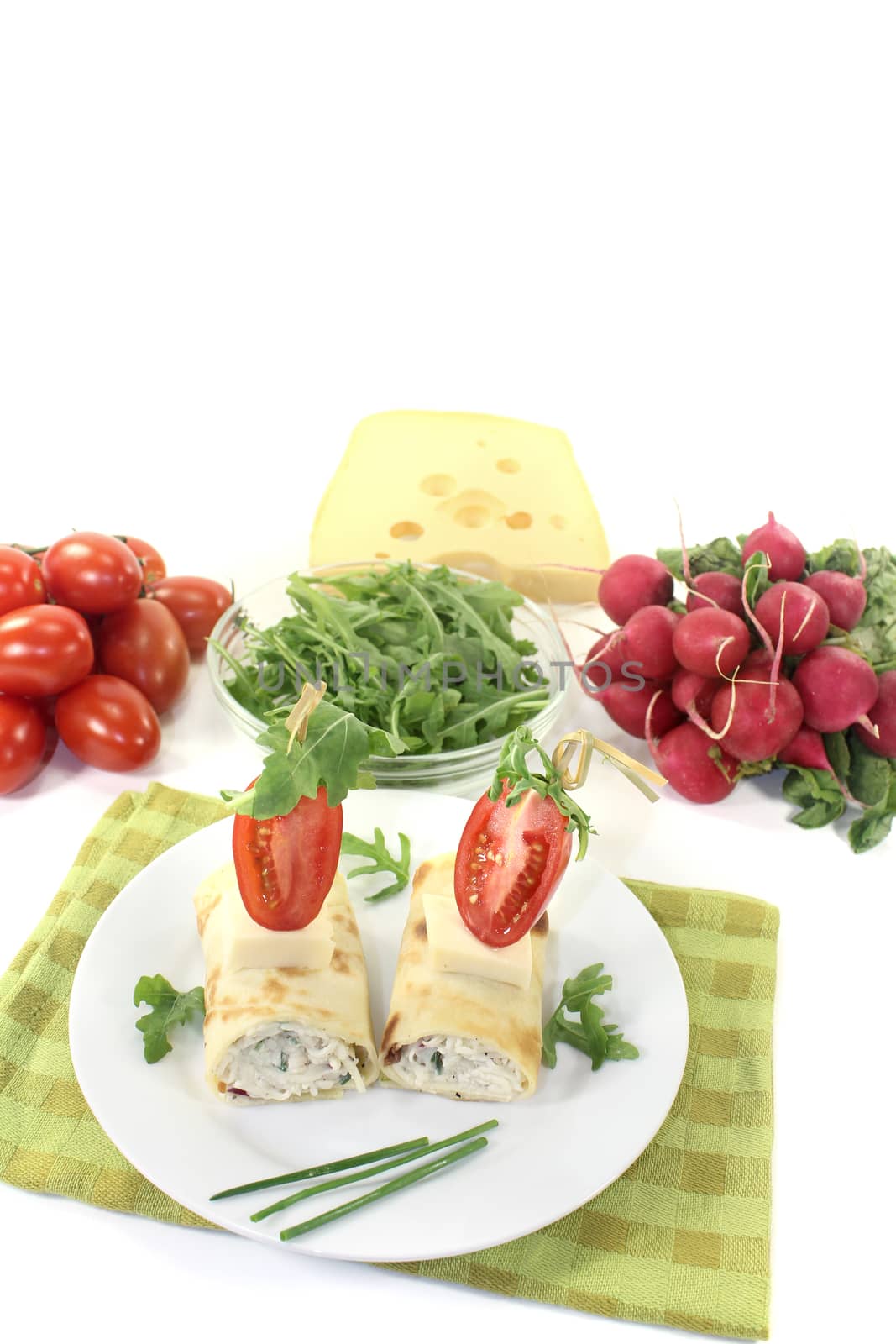 stuffed cheese crepe rolls with arugula on a light background
