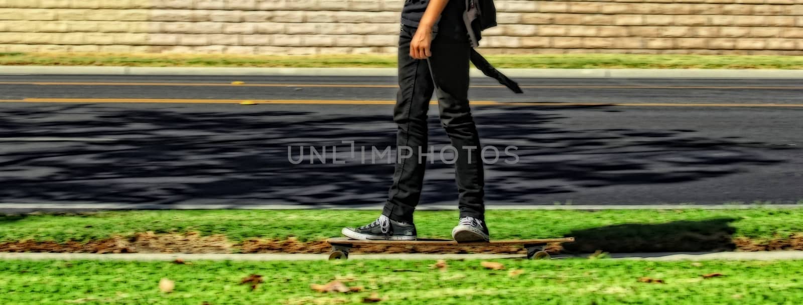 Teen skateboarding on the footpath.