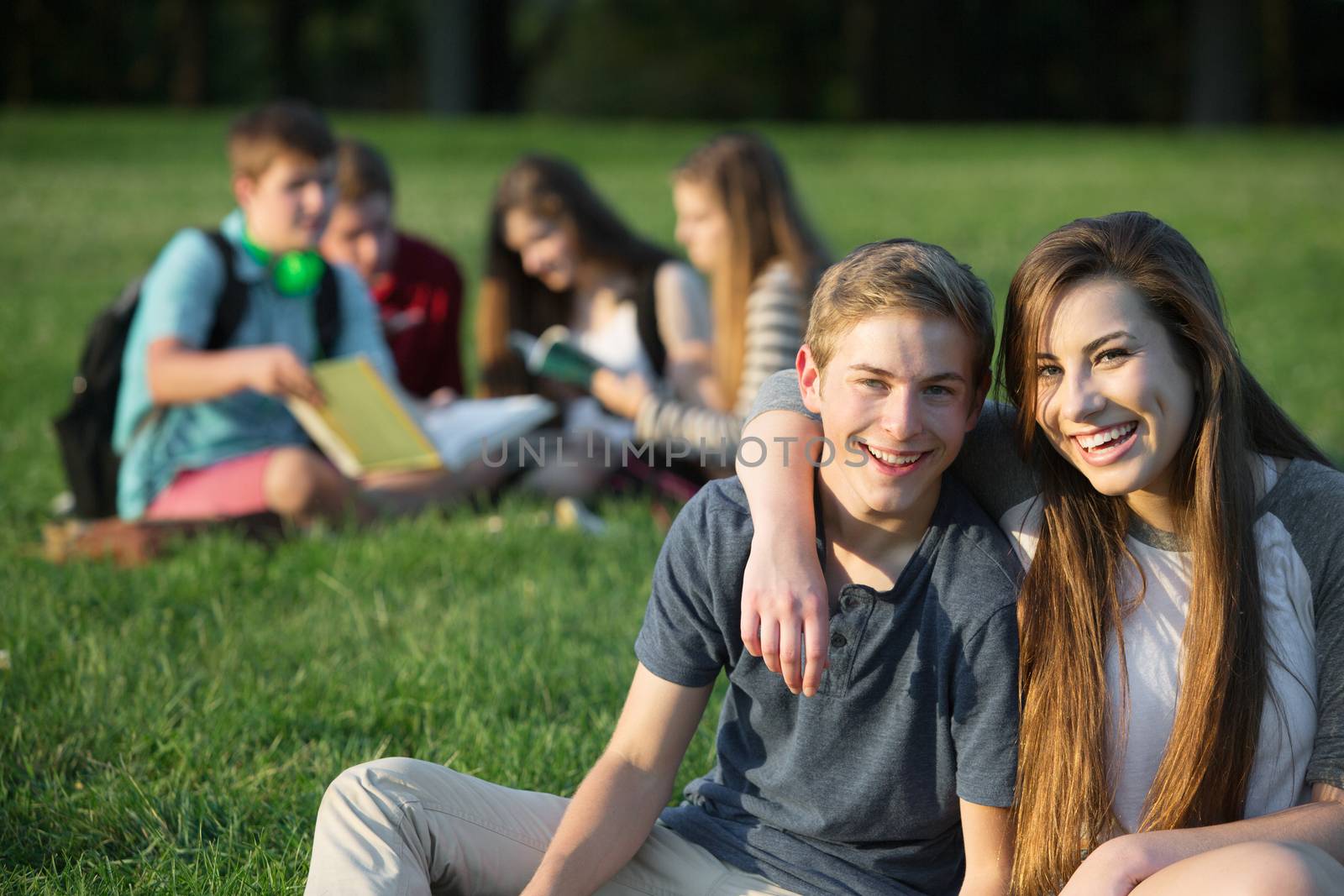 Cute male and female teens outdoors embracing