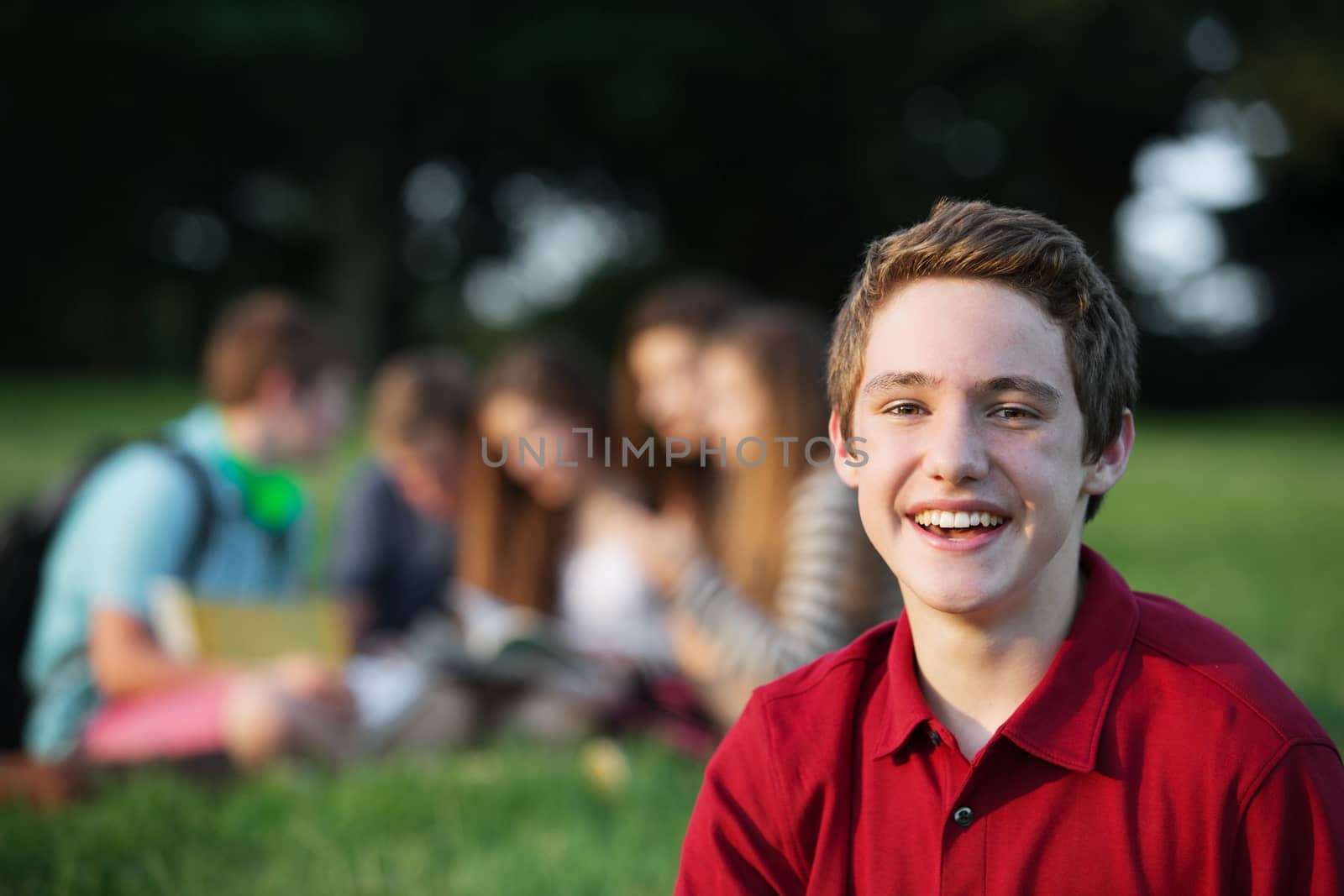 Laughing single male caucasian teen in red shirt
