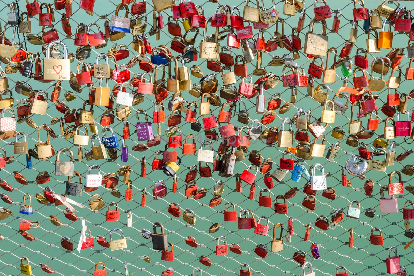 Plenty of colorful locks hanging on the bridge as a sign of eternal love devotion and loyalty of lovers