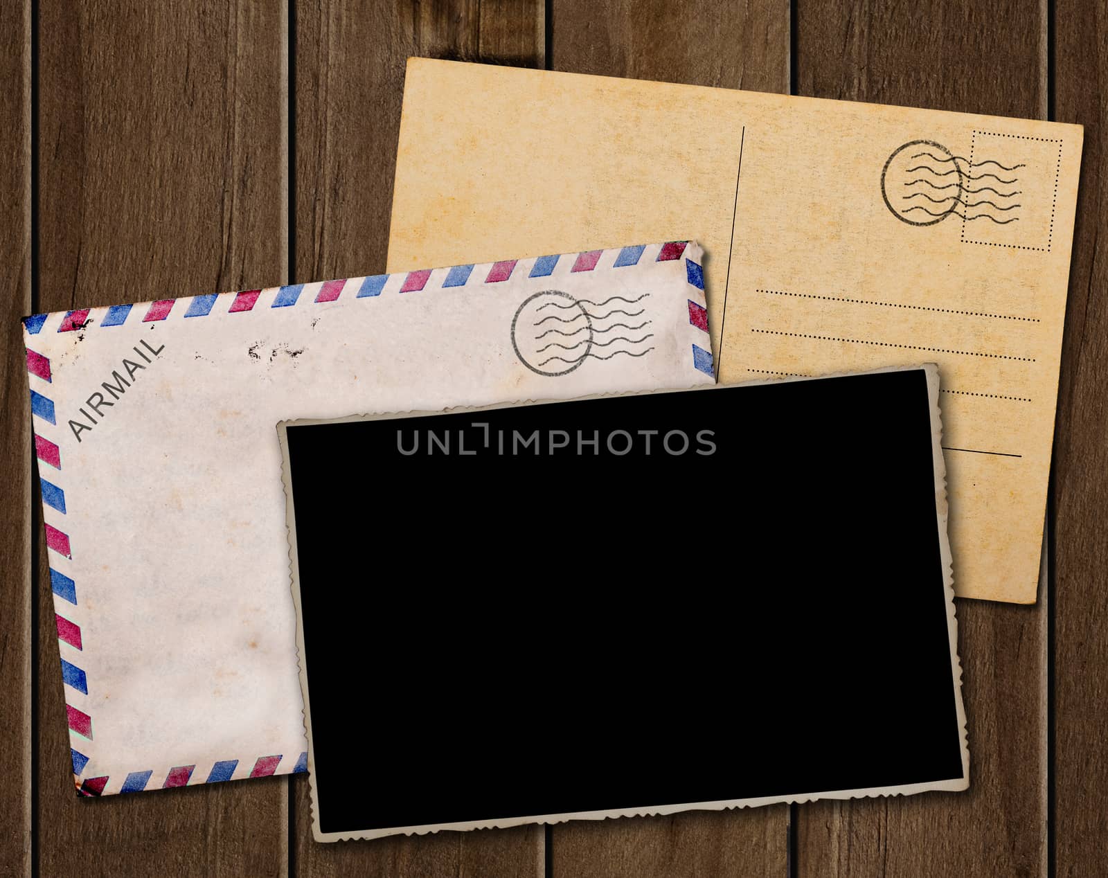 Old postcard, photo and envelope on wooden table.