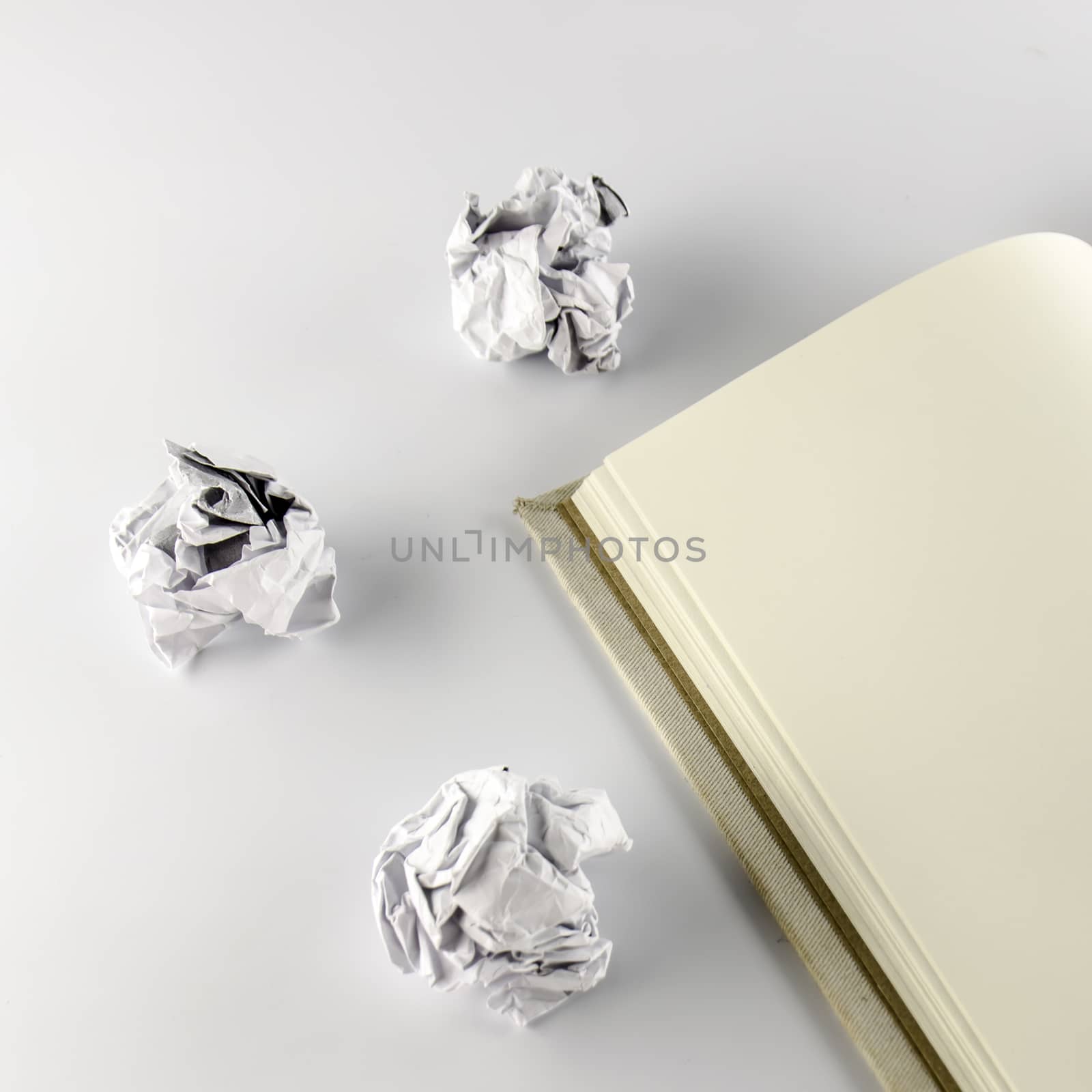 crumpled paper and notebook on a white background