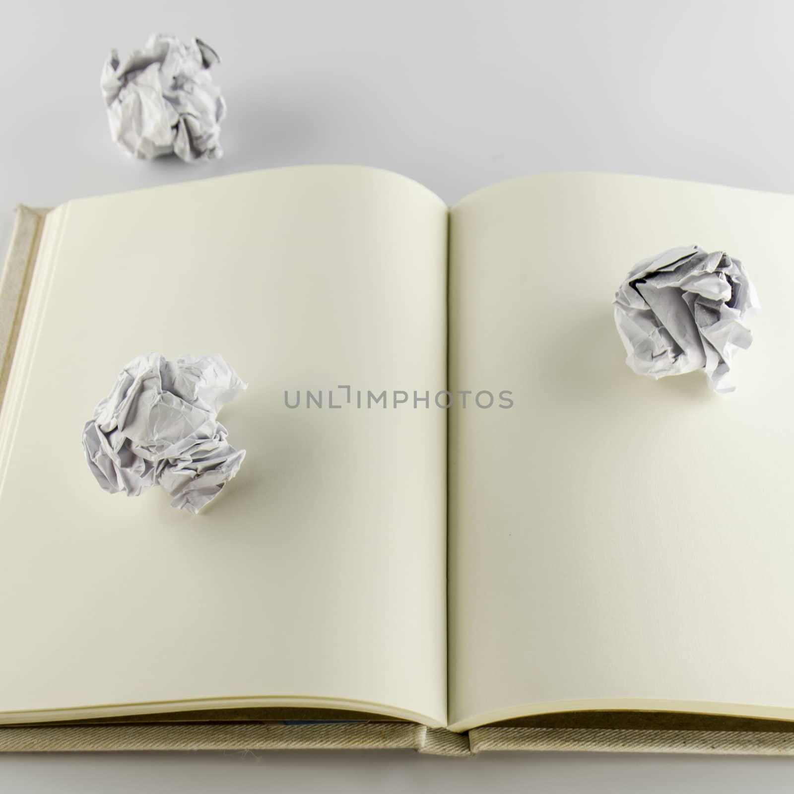 crumpled paper and notebook on a white background