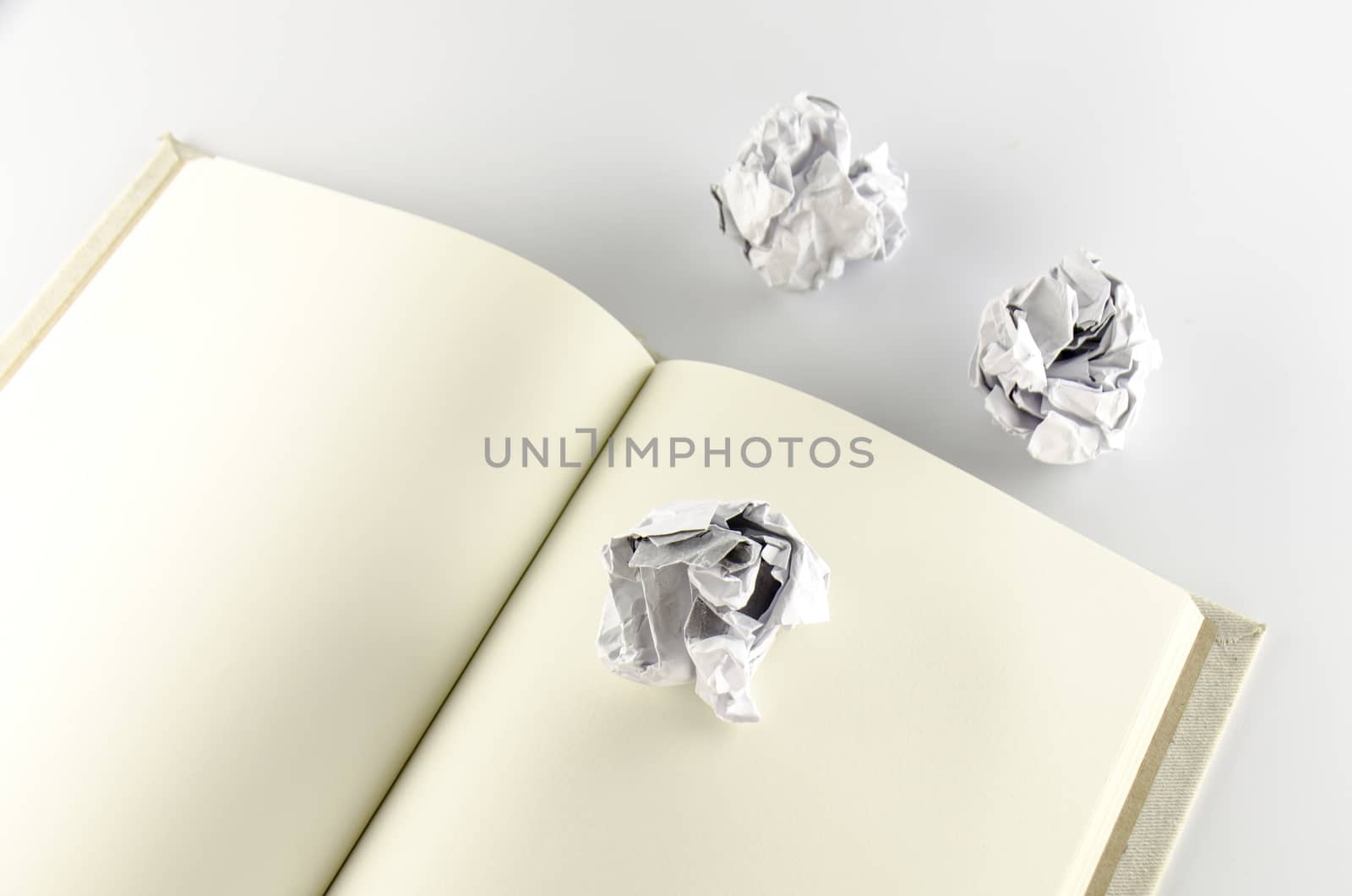 crumpled paper and notebook on a white background