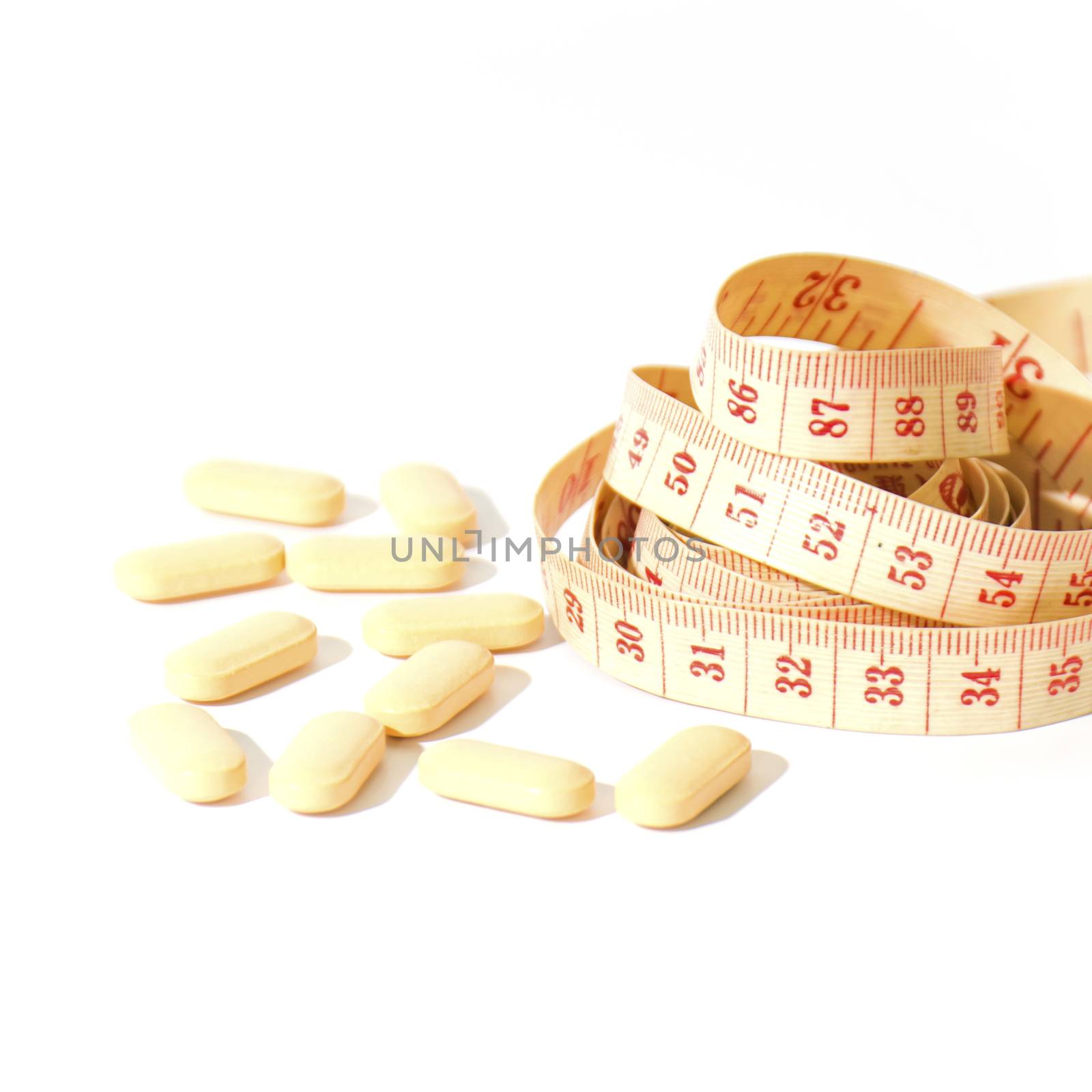 pills and measuring tape on a white background