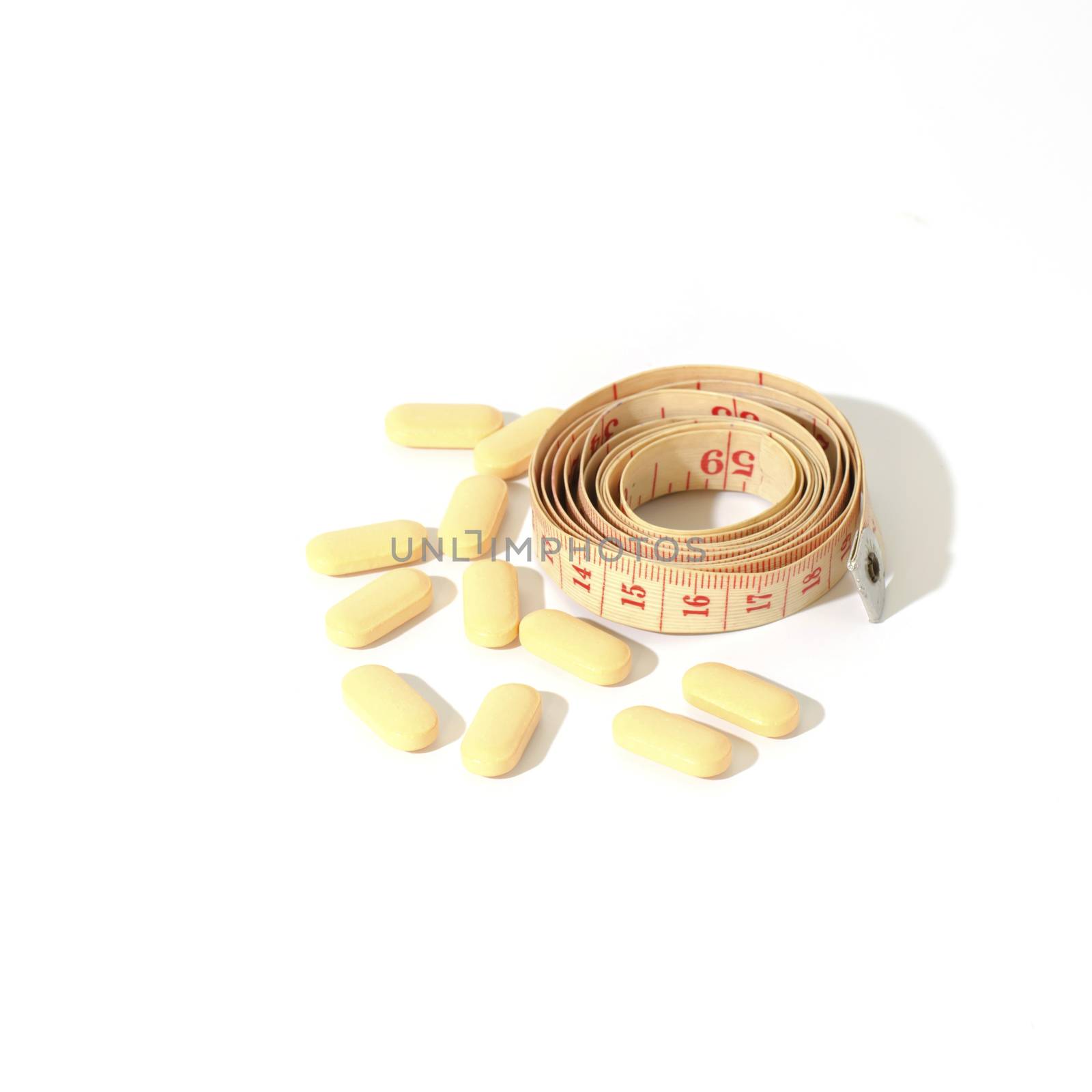 pills and measuring tape on a white background