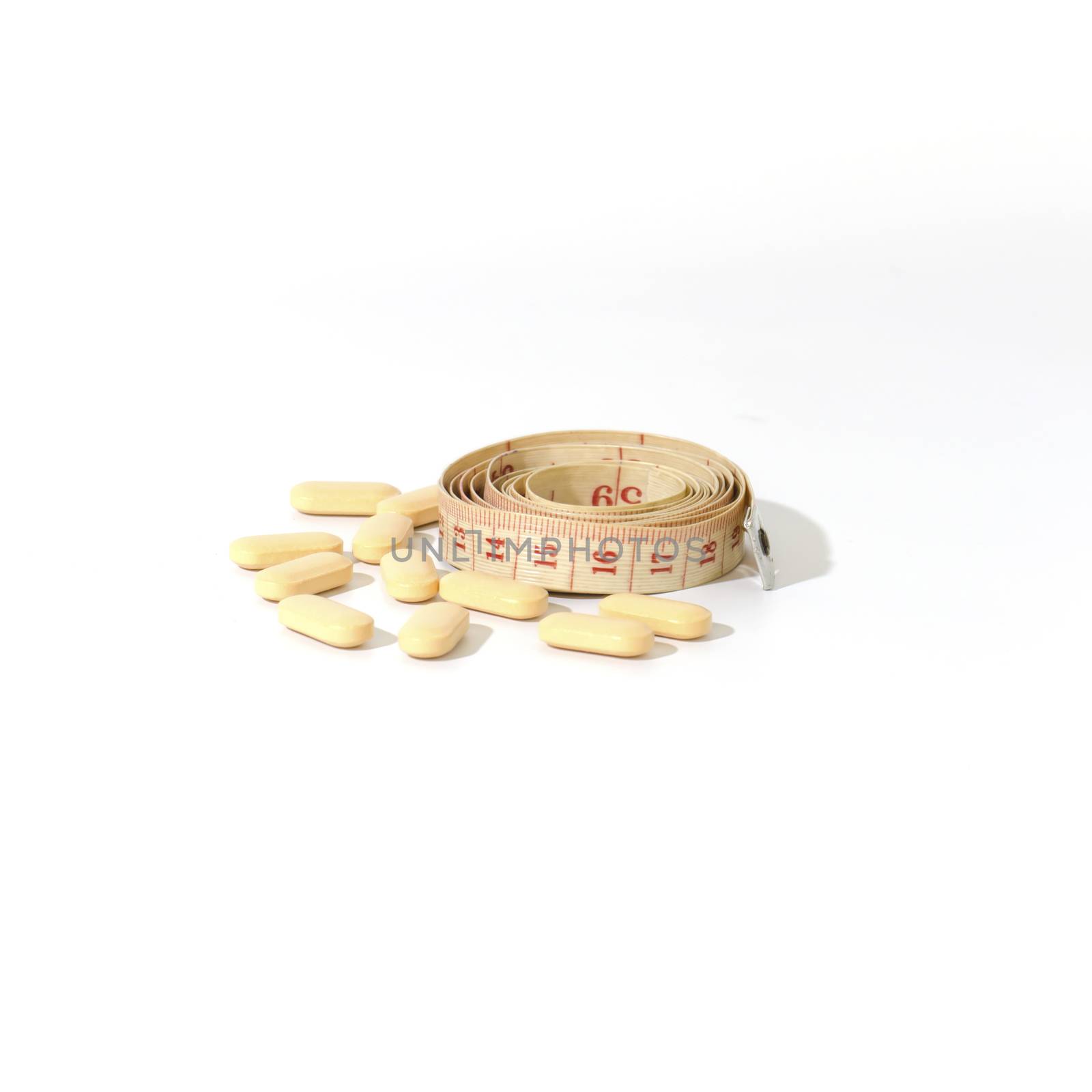 pills and measuring tape on a white background