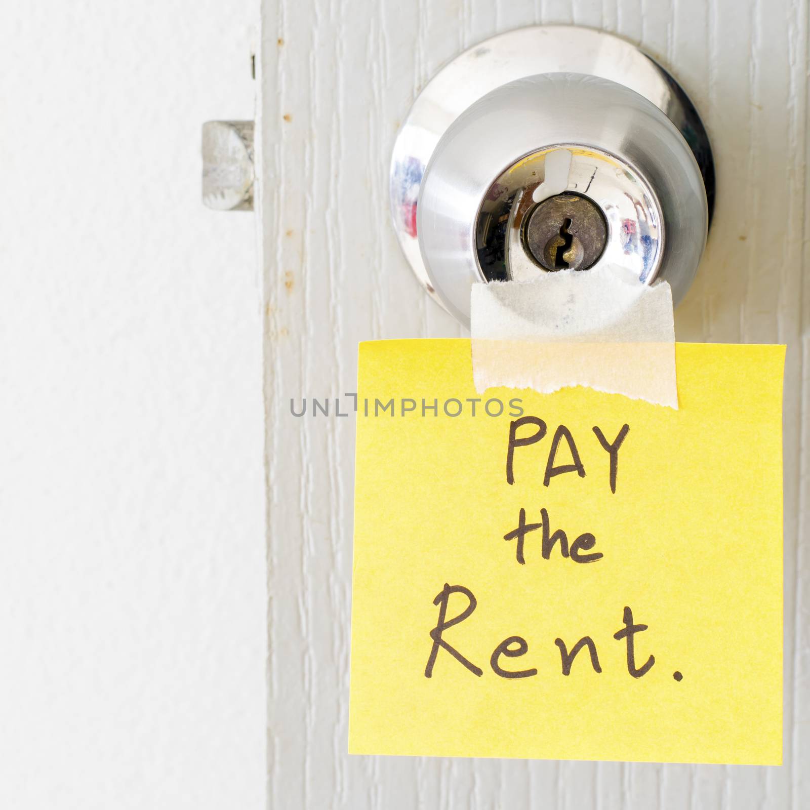 sticky note write a message pay the rent on the latch door