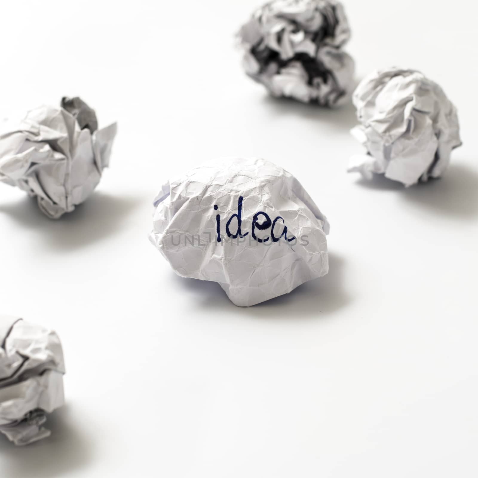 white crumpled paper ball focus idea word on a white background