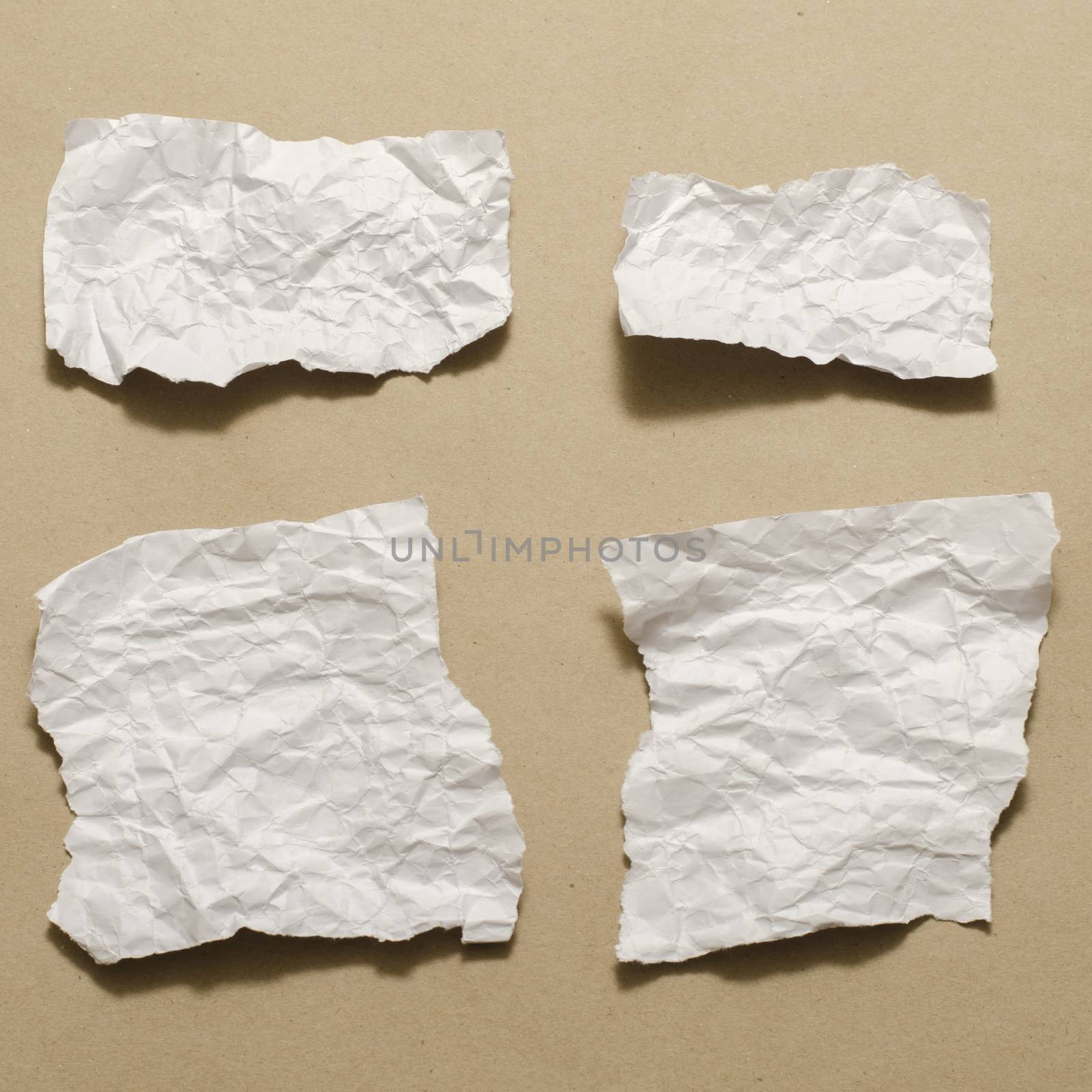 piece of white crumpled paper on brown background