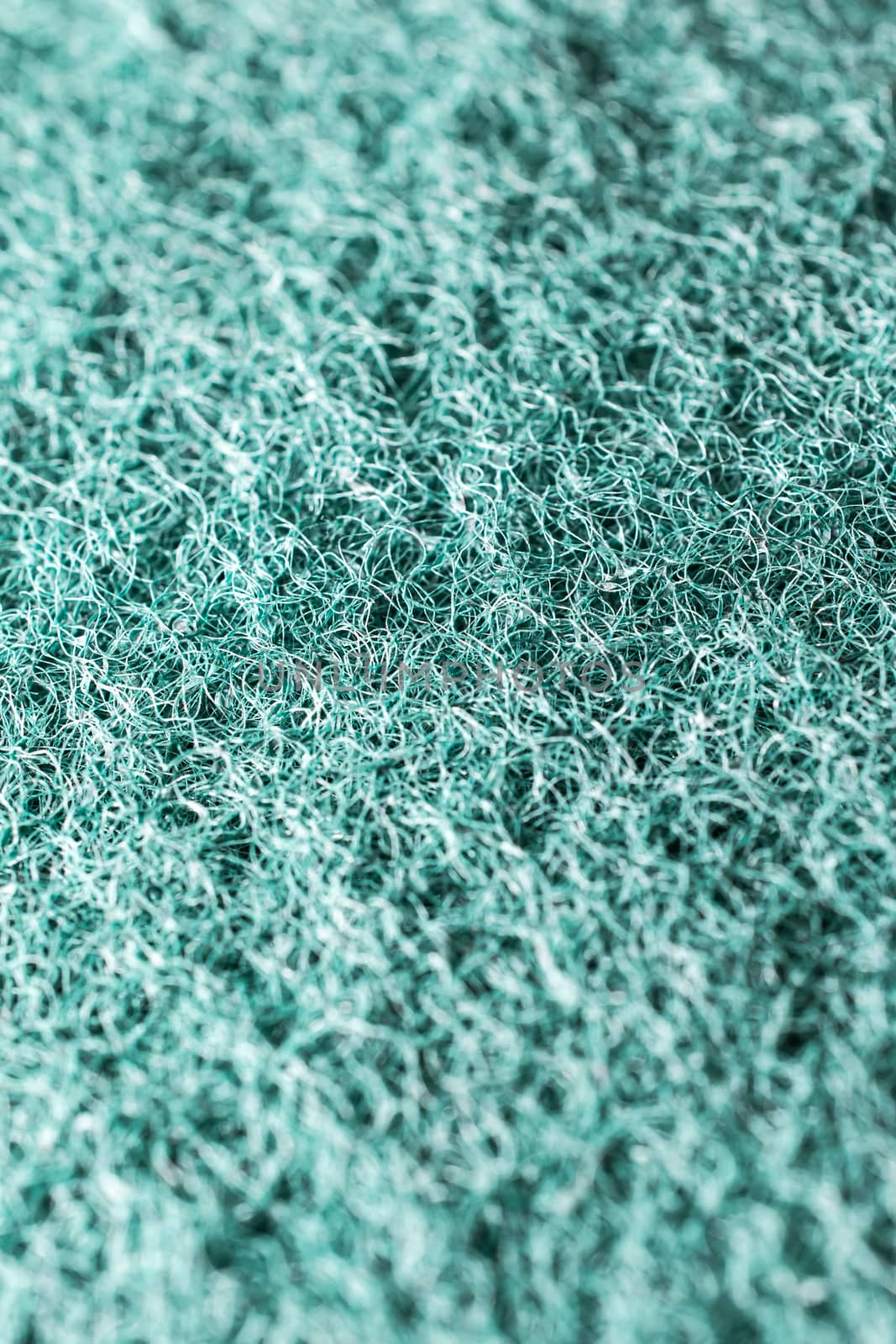 Close-up of a green cleaning sponge surface as a backdrop backgr by pitchaphan