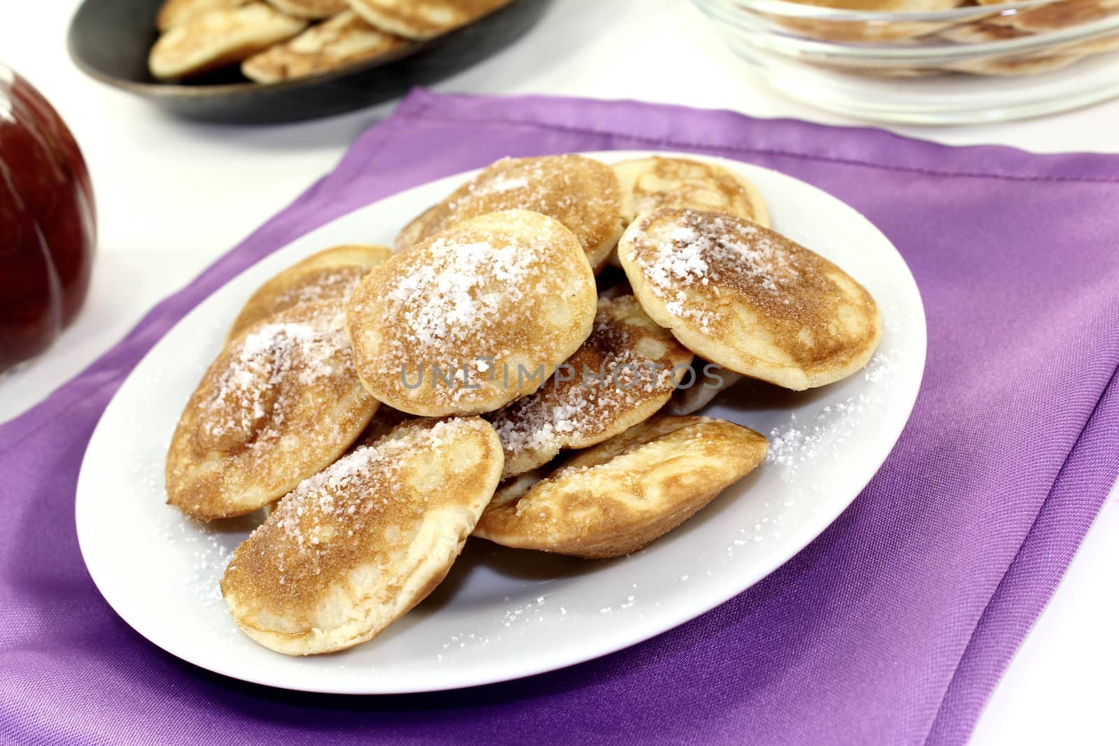 Poffertjes with sweet powdered sugar on a light background
