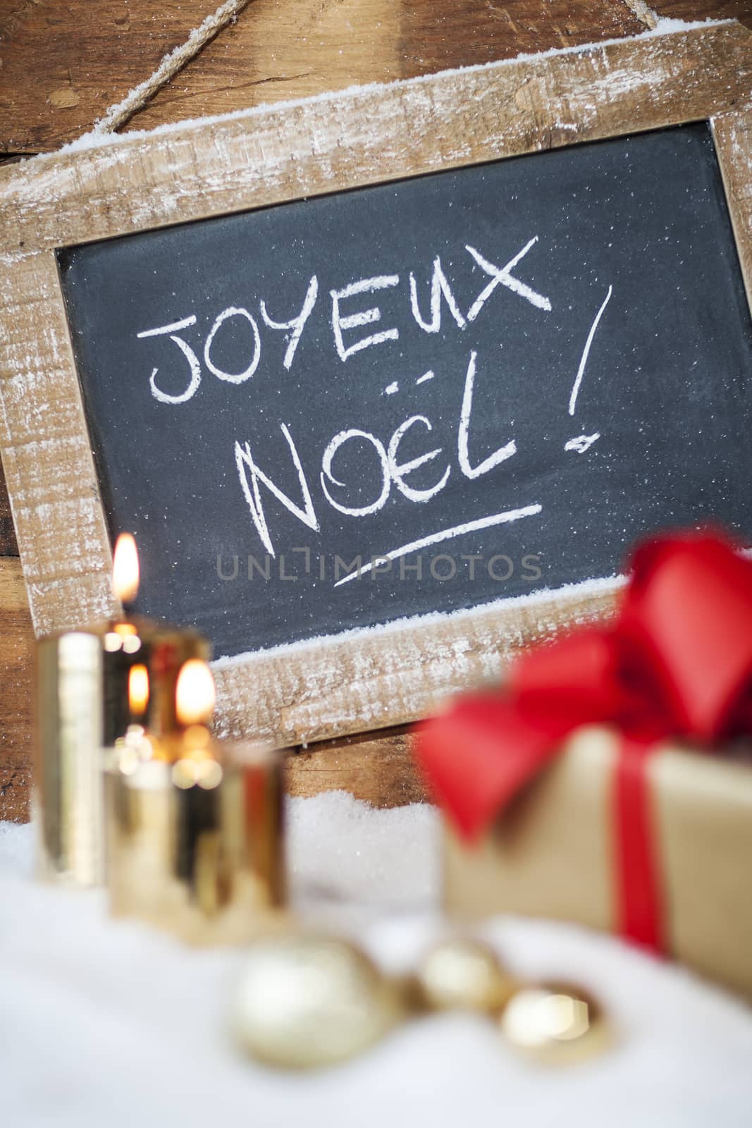 Vertical view of Christmas gifts with candles and slate.