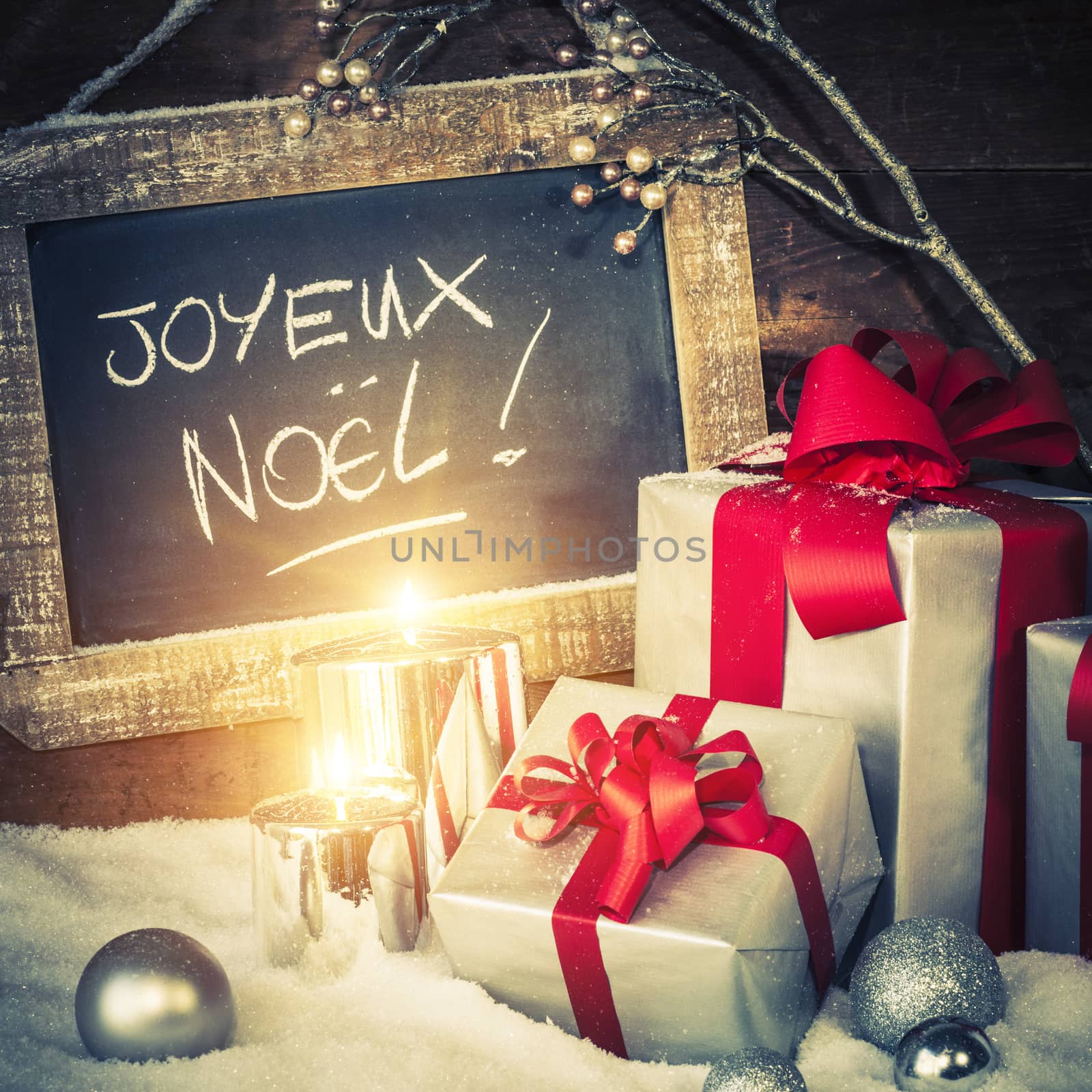 Closeup of Christmas gifts with lighted candles and slate.