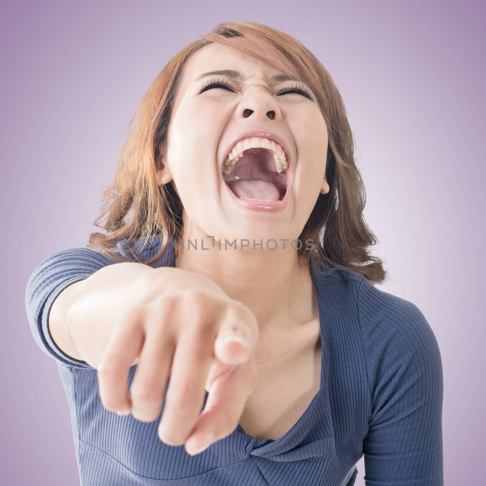 Asian woman pointing and laughing at you, closeup portrait.