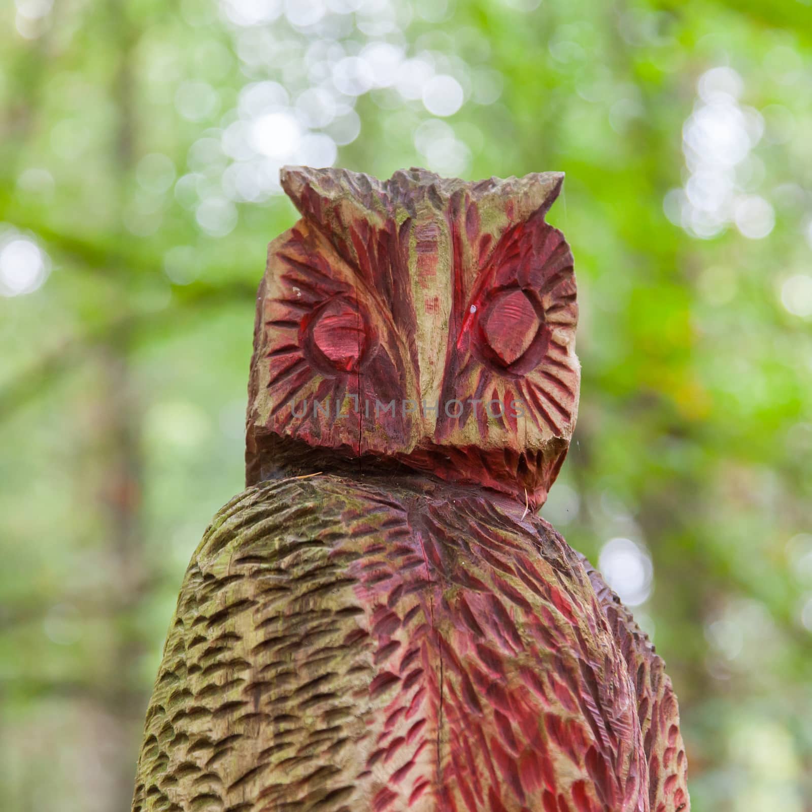 Old wooden carved owl in a forrest