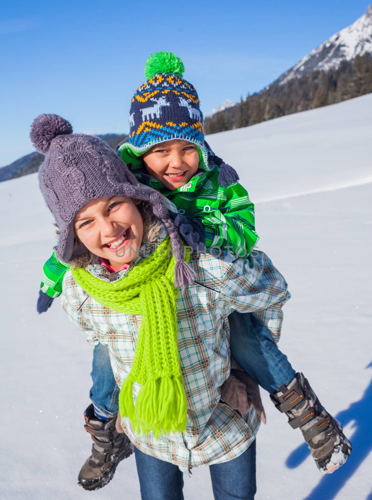 Two happy kids playing winter on the snow in Alps